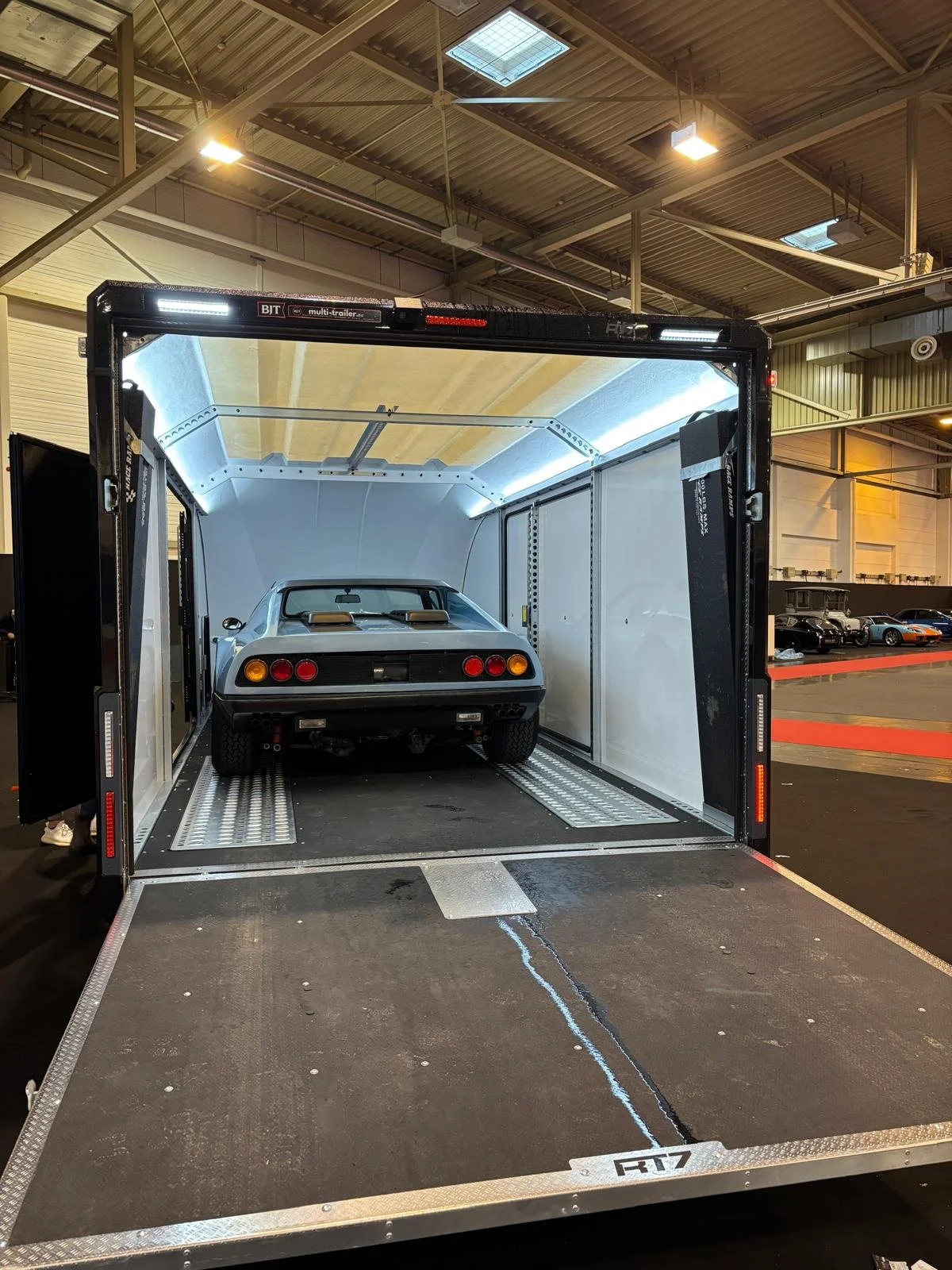 A blue Ferrari 365 GTB in an enclosed cartrailer (brian james RT7 trailer), ready for transport.