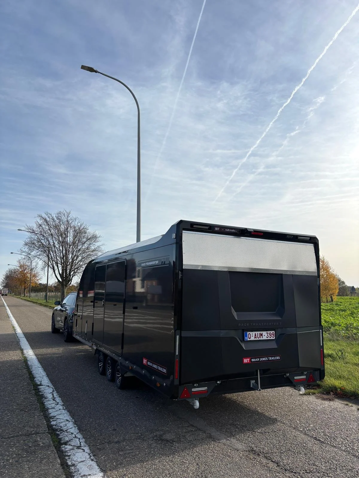 The back of an enclosed black Brian James RT7 trailer parked on the side.