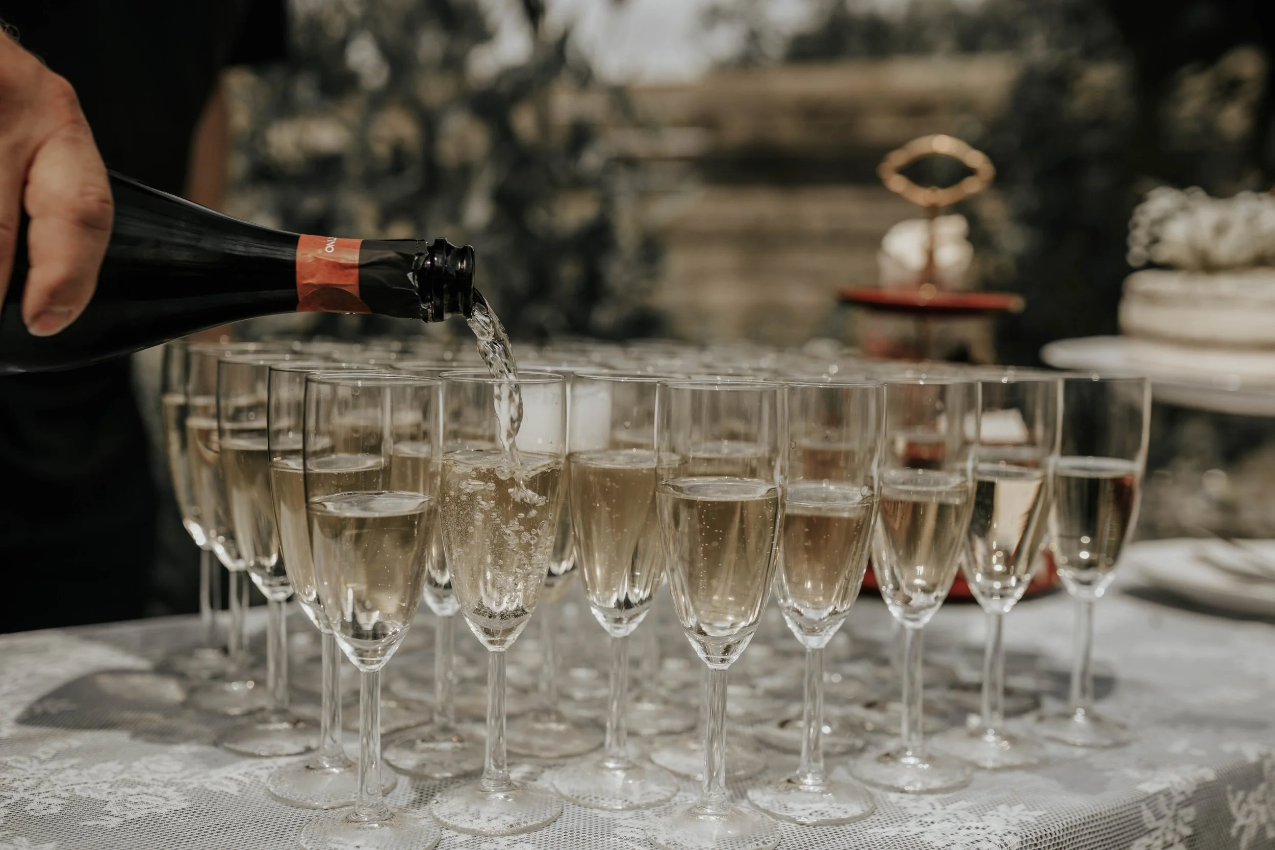 Persoon giet champagne in glazen op een tafel met een witte tafellaken