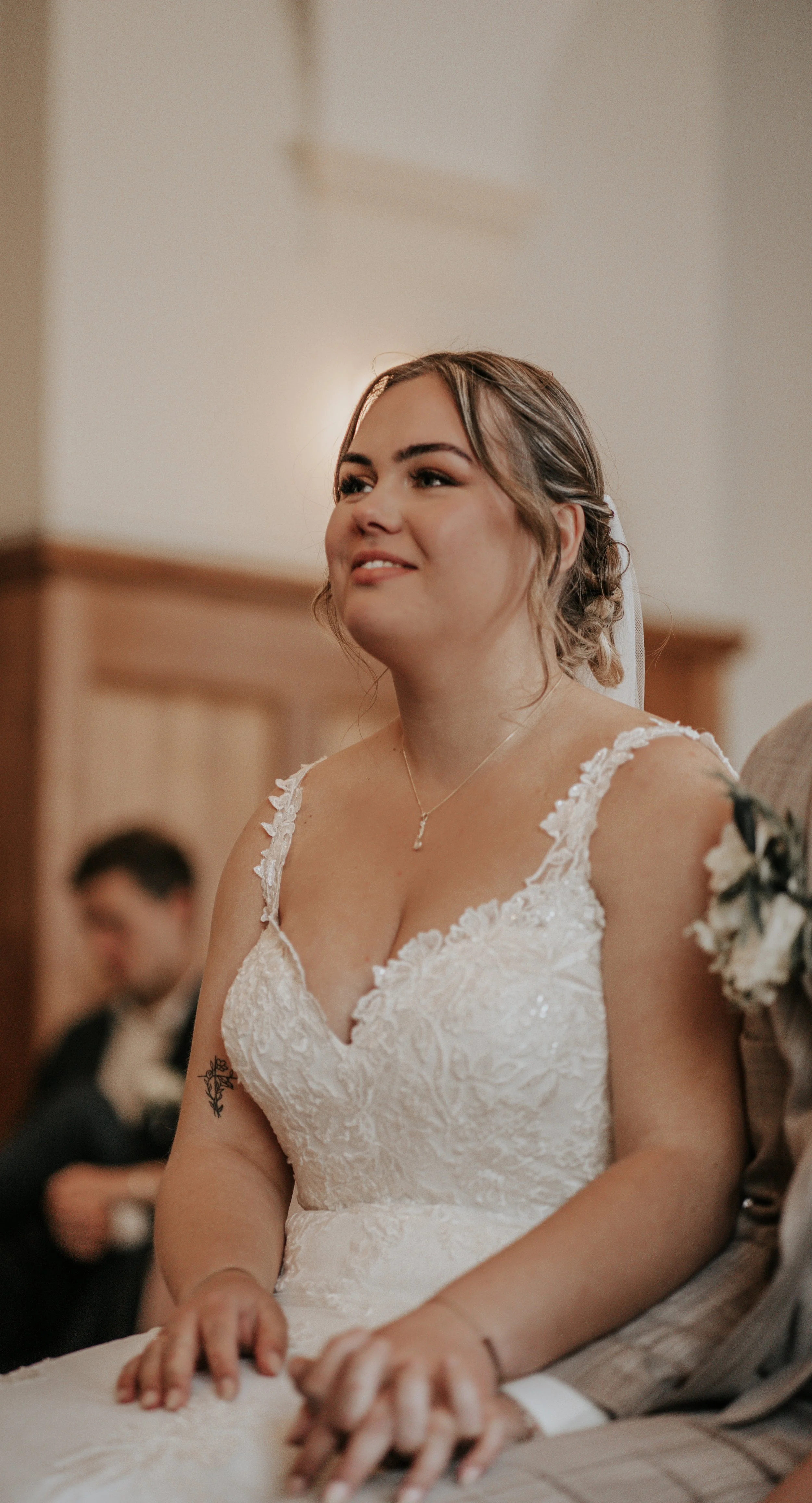 Een bruid met een witte kanten trouwjurk met bloemenapplicaties.