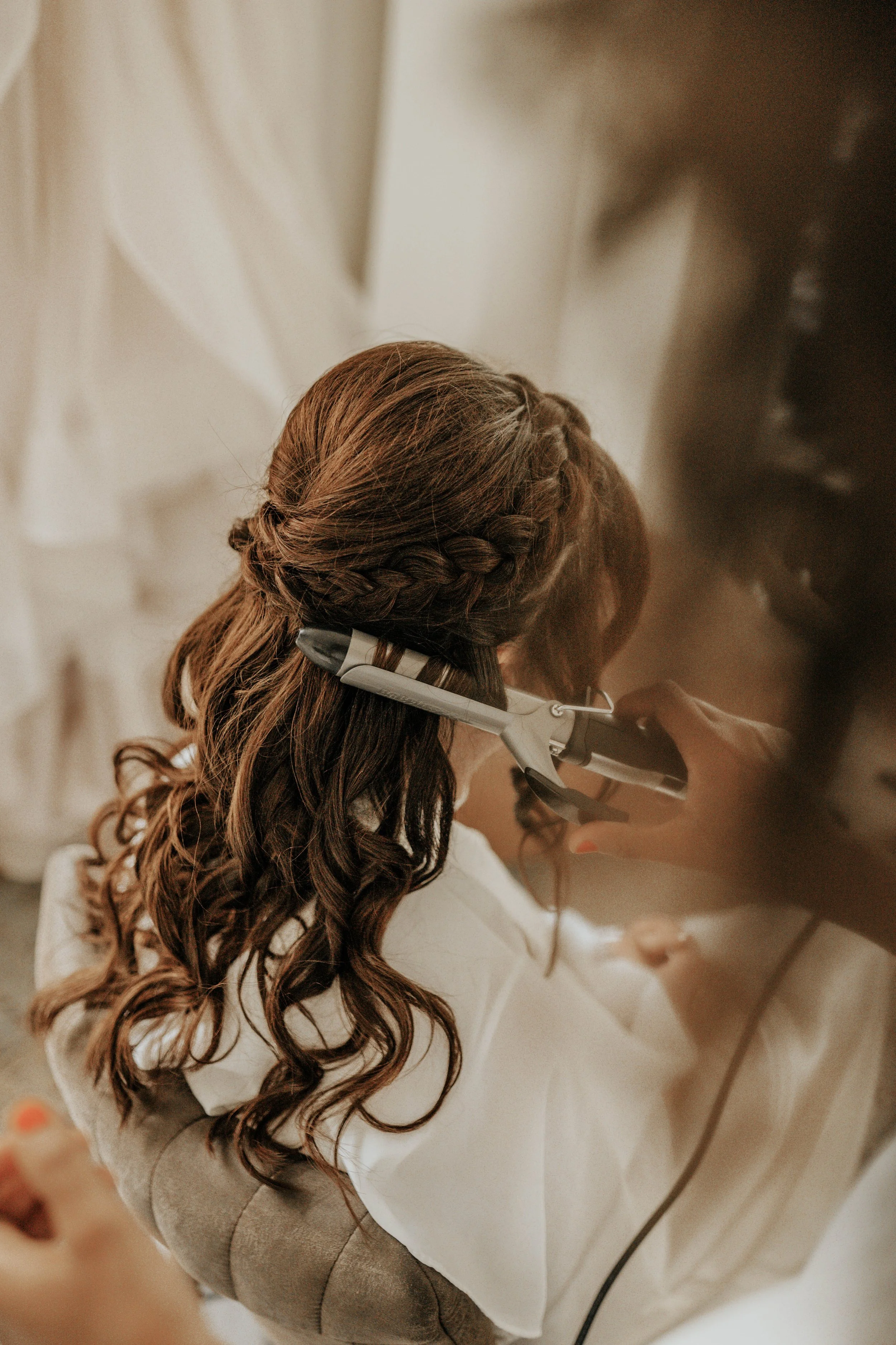 Vrouw krijgt een haargel haar styling met een krultang.
