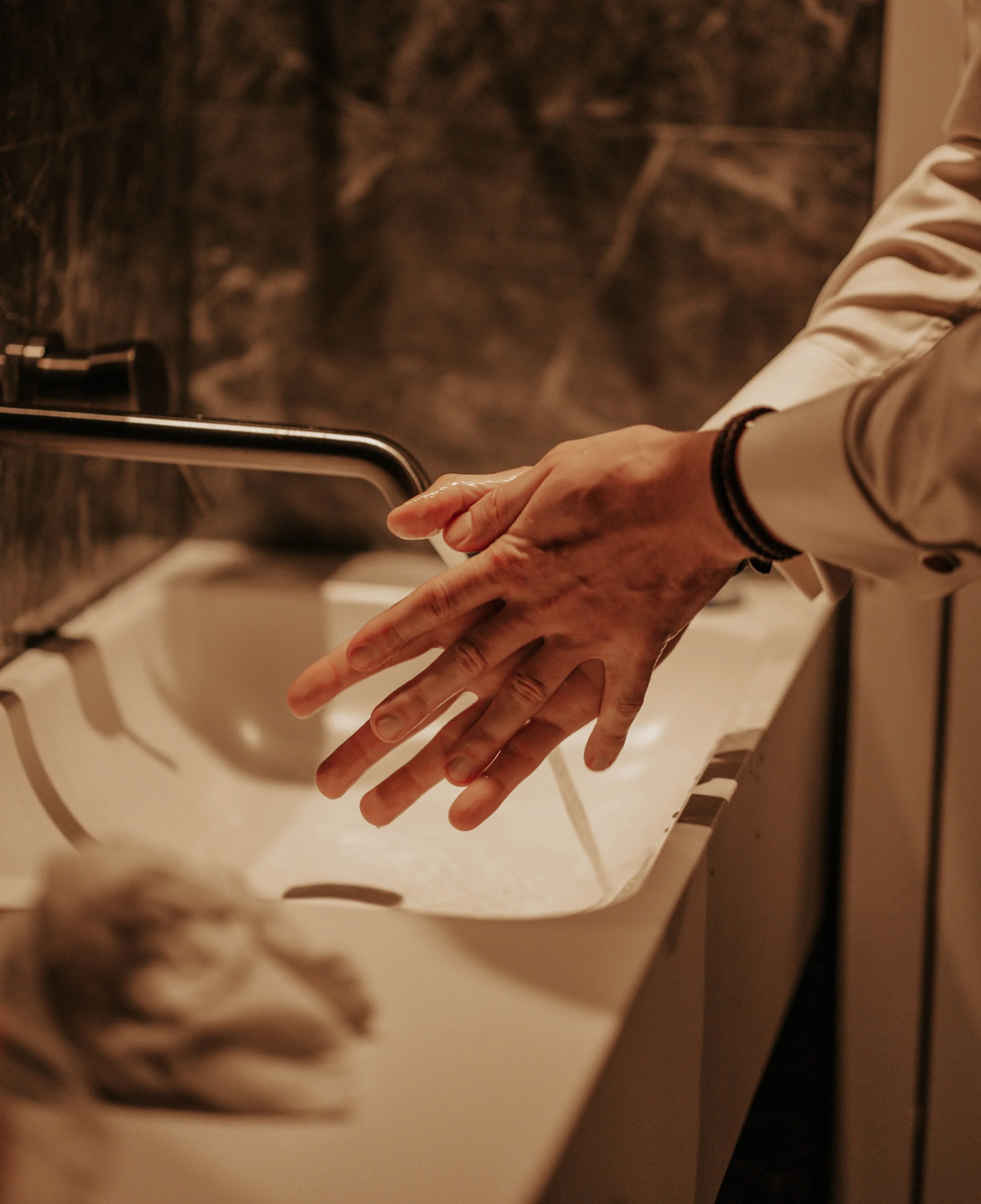 Persoon wast handen onder lopend water in een badkamer of keuken.