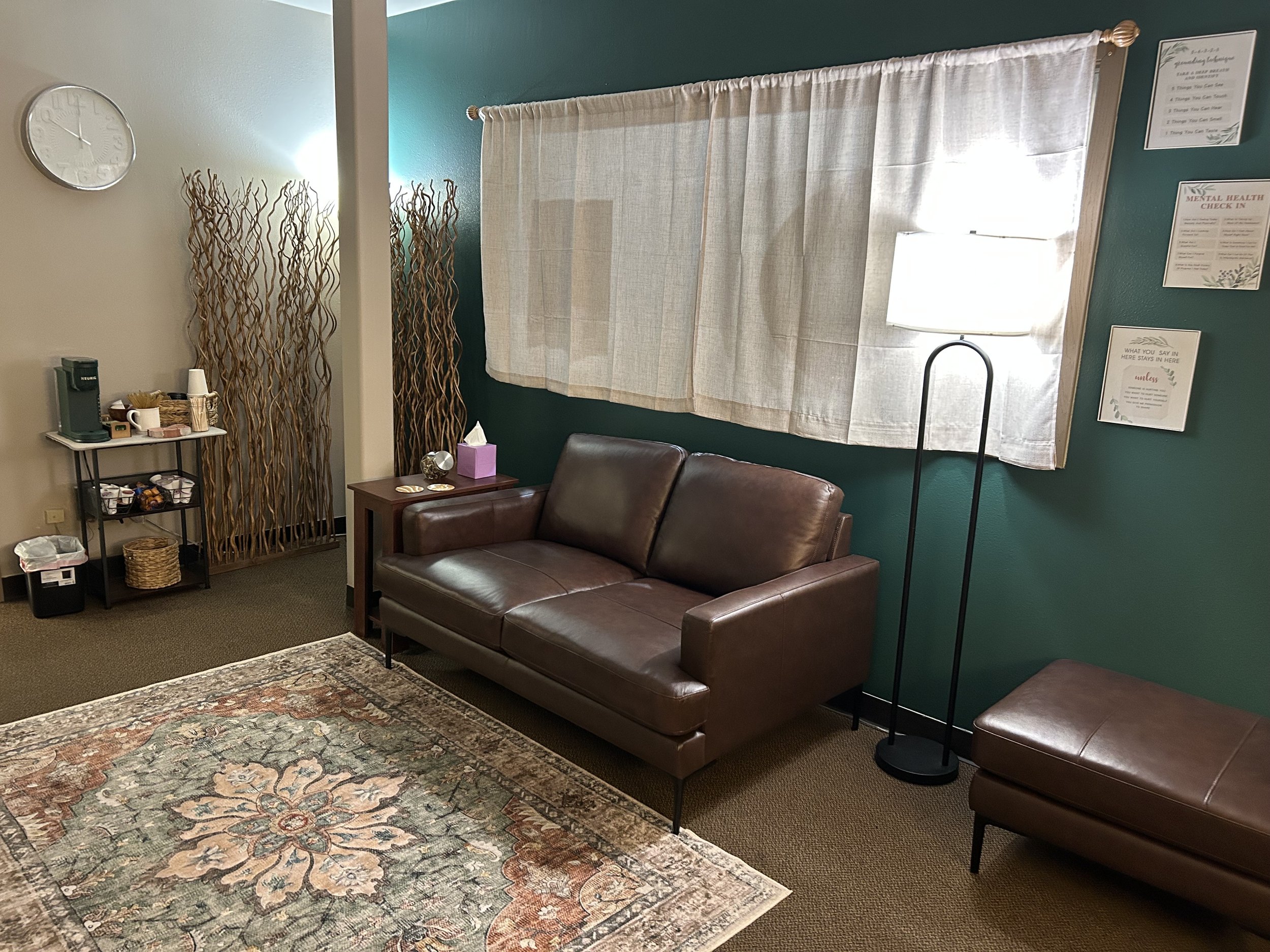 A cozy living room featuring a couch, a lamp, and a decorative rug on the floor.
