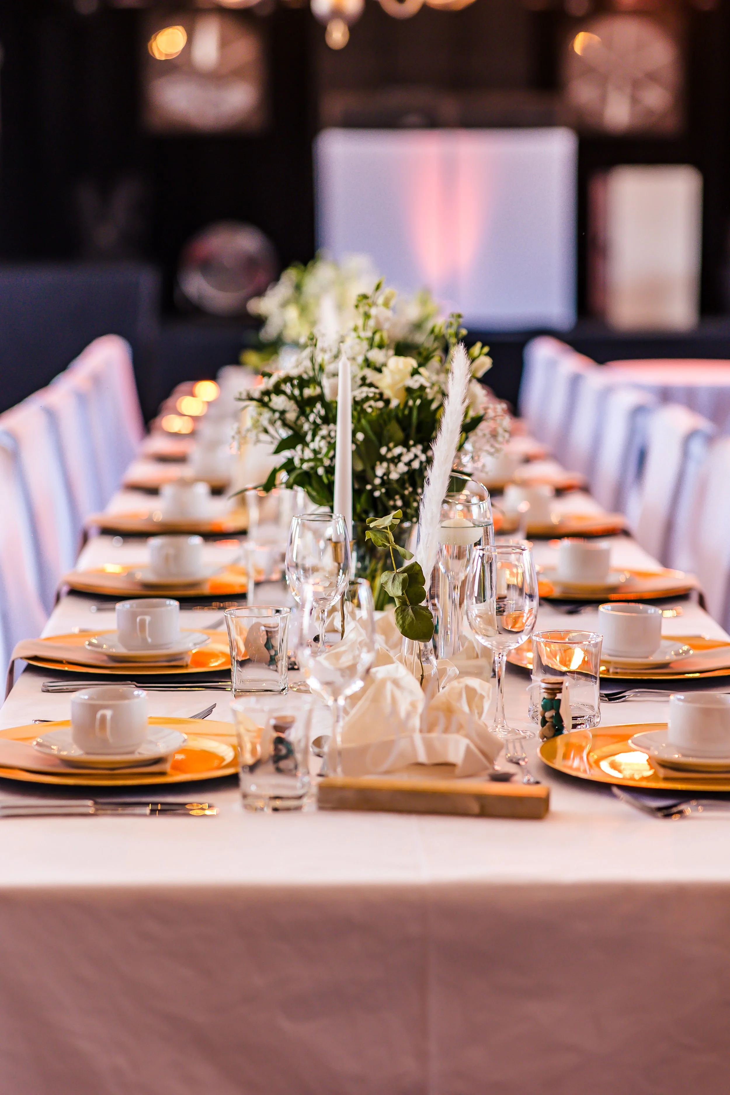 Festlich gedeckter Tisch mit Blumen, Kerzen, Geschirr und Gläsern bei einer Event Feier