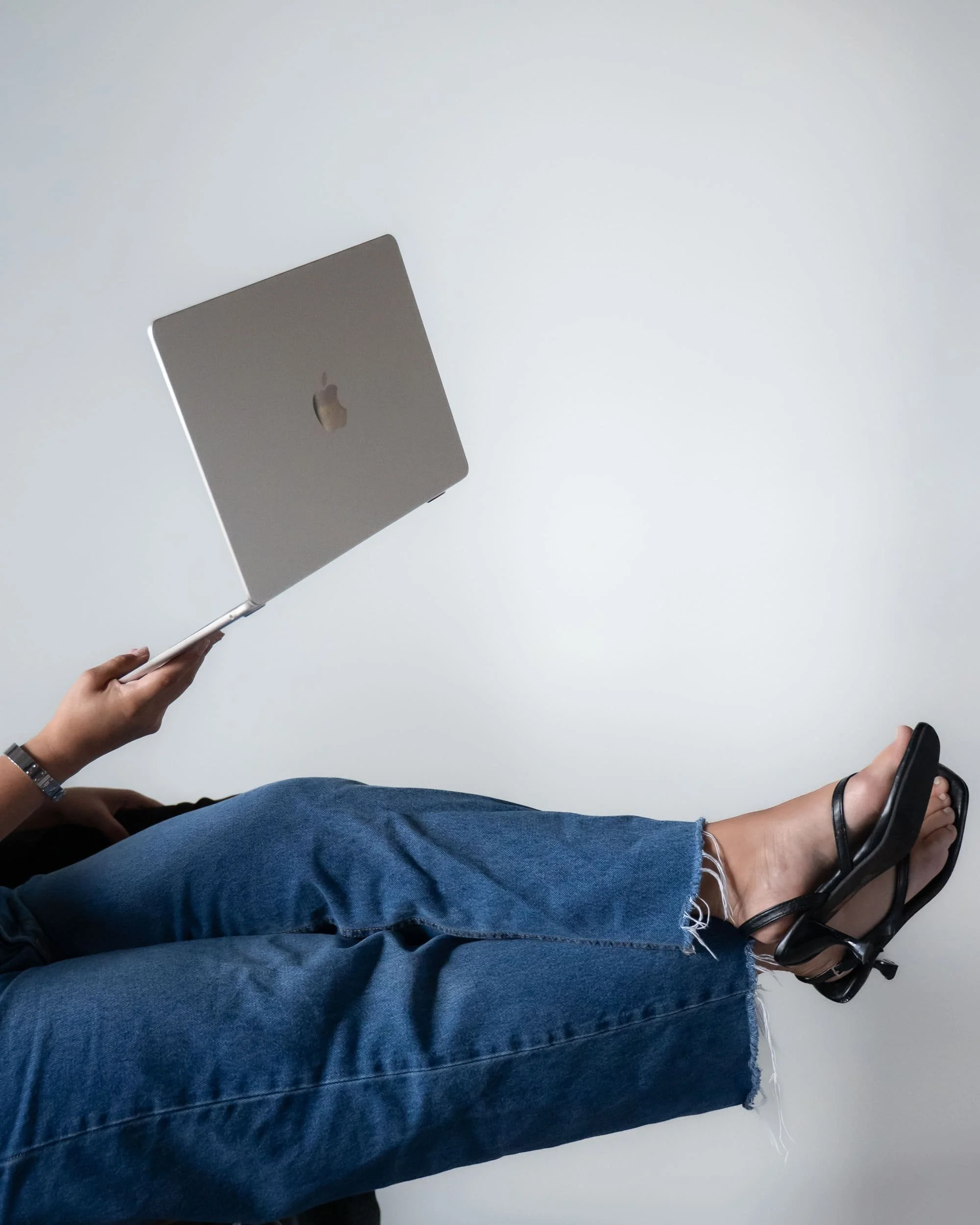 Close-up of an arm holding a laptop for Dot Creative brand imagery.