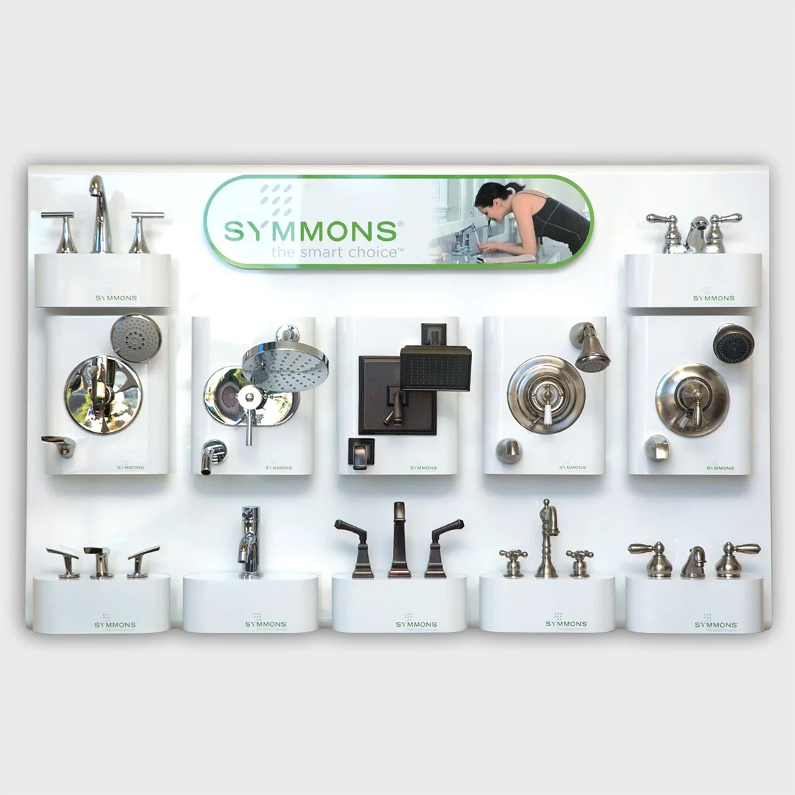 Display of various shower and faucet fixtures by Symmons, including showerheads, faucets, and handles, on a white panel with the Symmons logo and slogan.