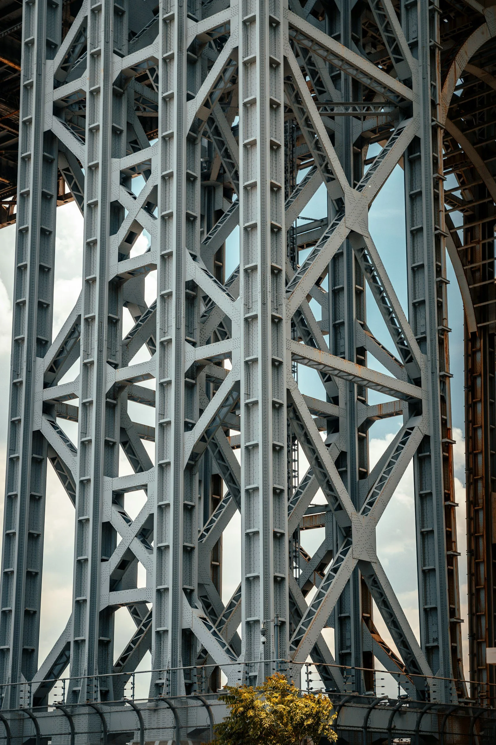 Close-up view of the steel structure of a bridge with numerous intersecting beams and girders.