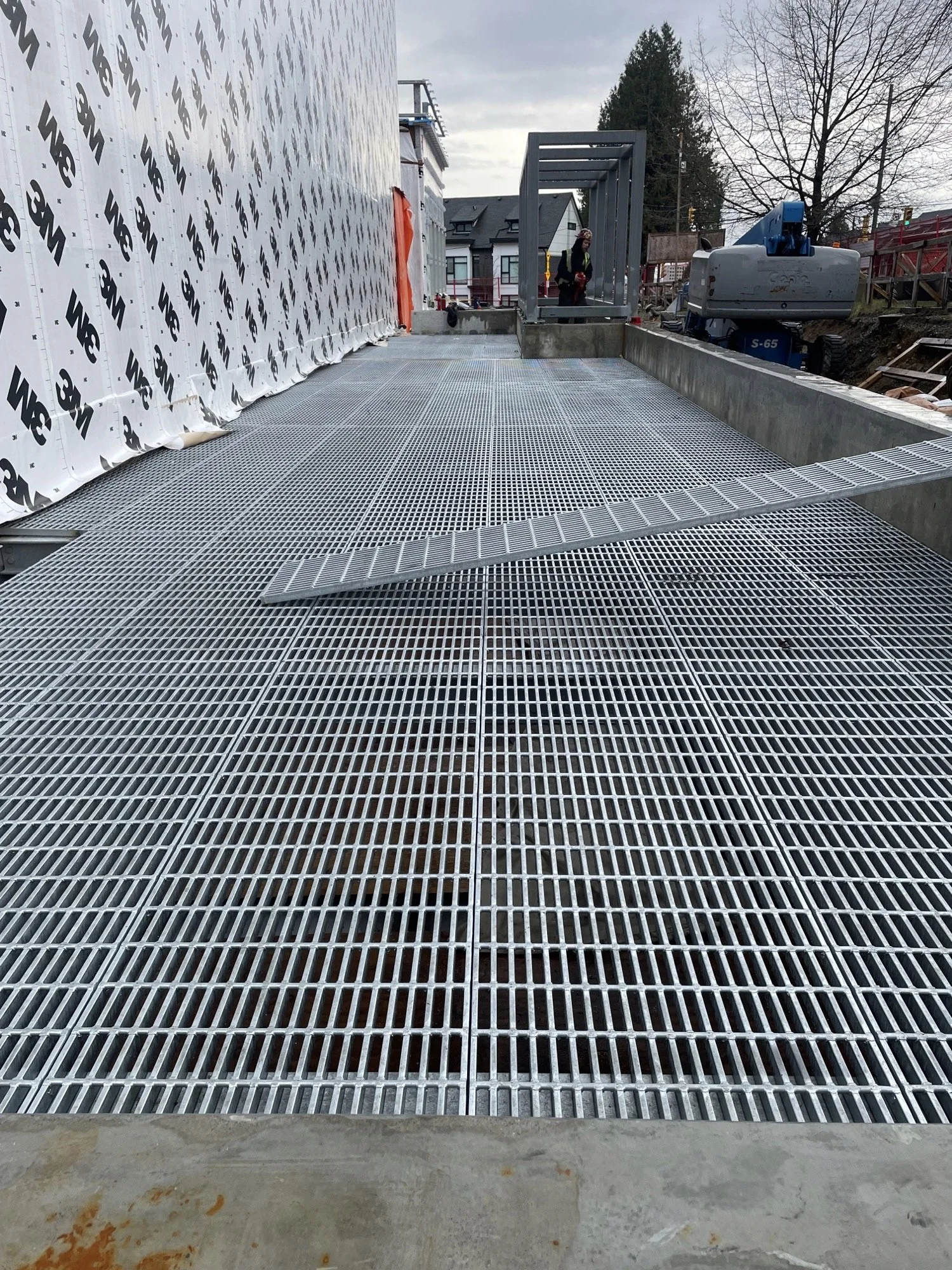 Industrial metal structure with stairs, railings, and a large rusted vertical tank.