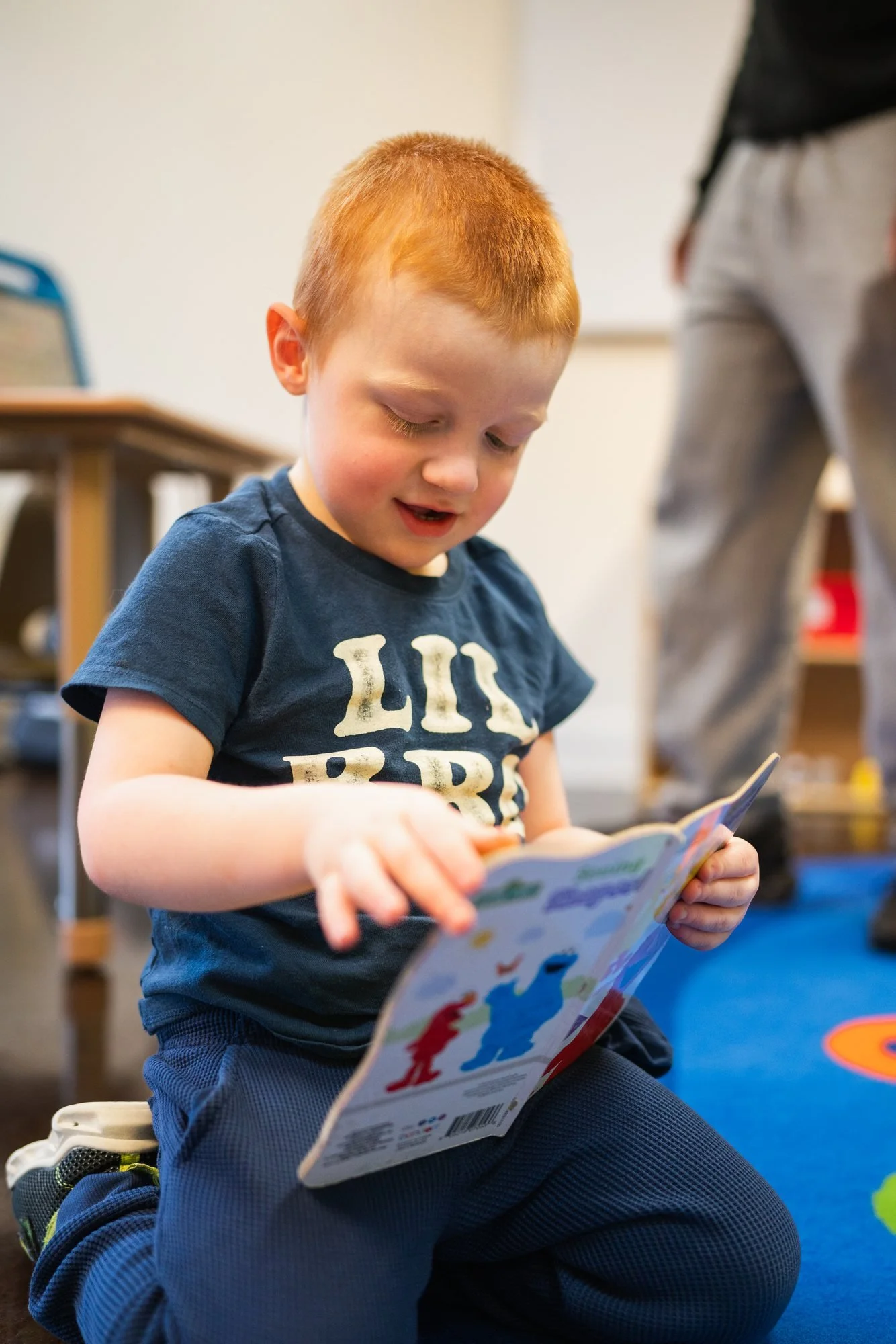Child reading a picture book during a session at StarBright Centers
