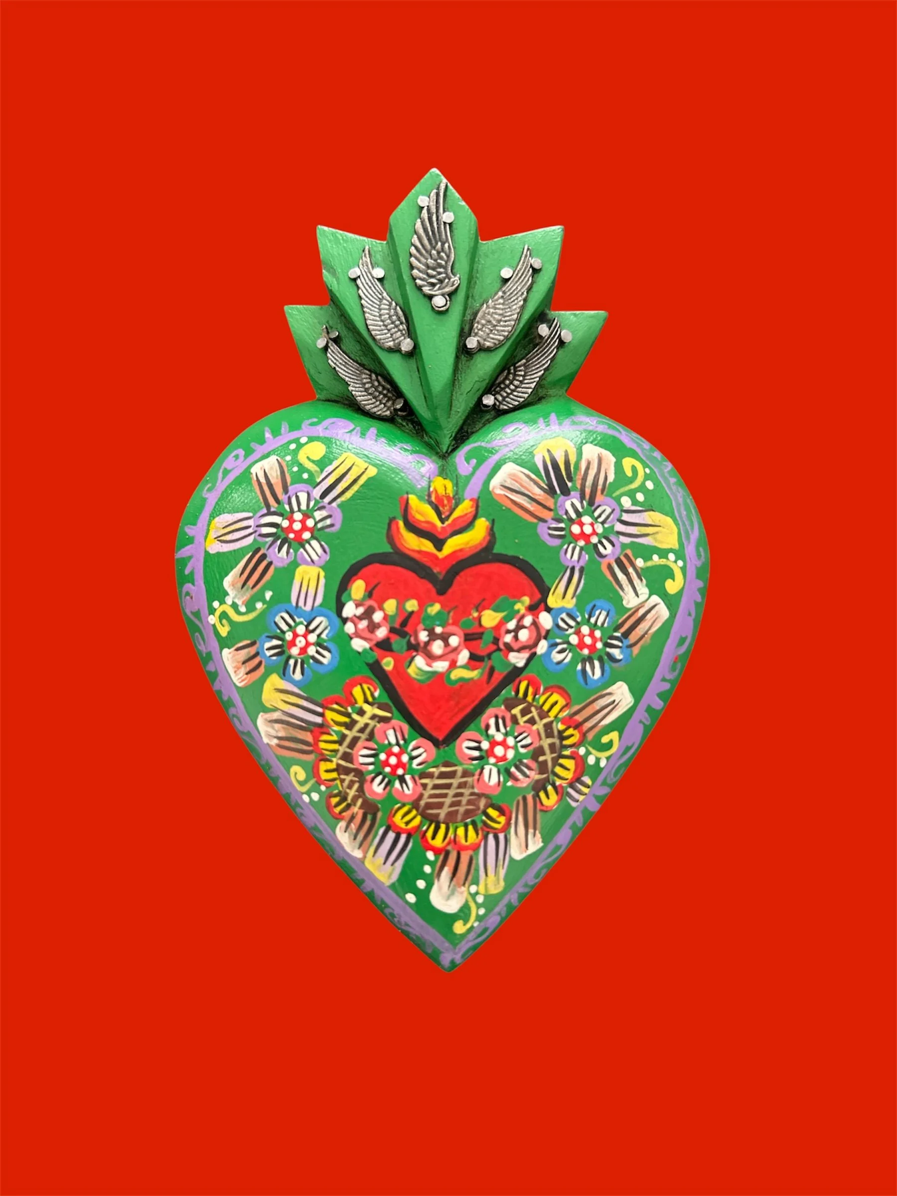 Decorative Mexican milagrito heart with painted sacred heart