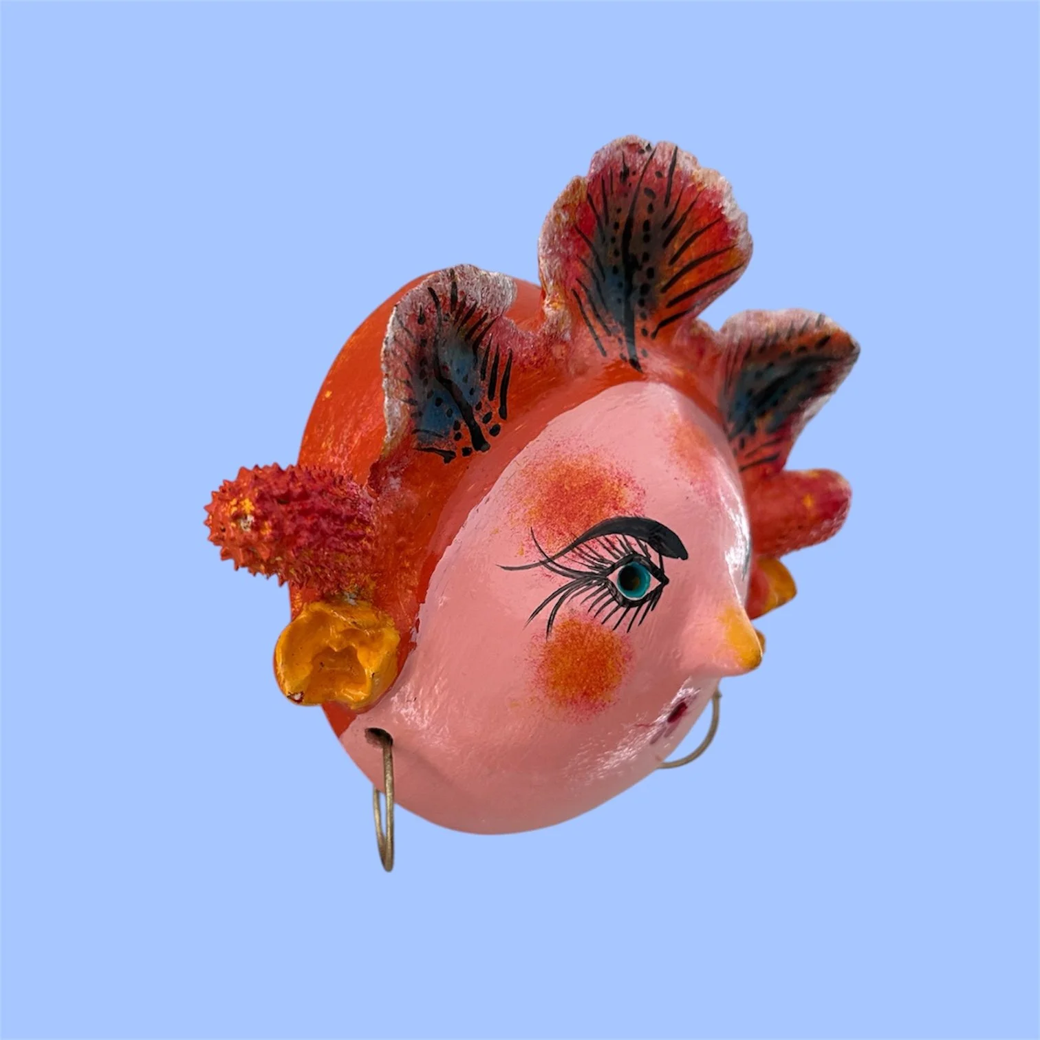 Side view of a handcrafted Mexican coconut mask featuring a woman with leaves.