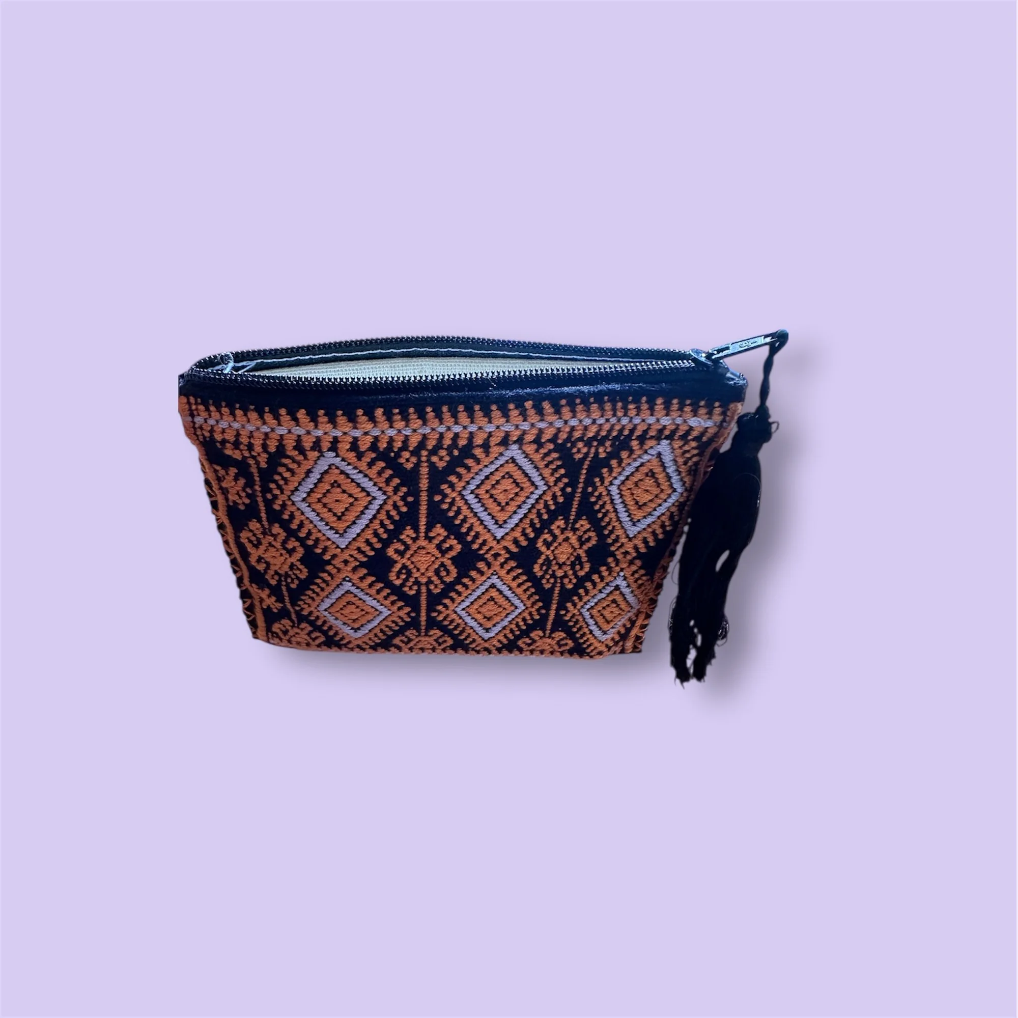 Close-up detail of black embroidered coin purse featuring traditional Mexican stitching.