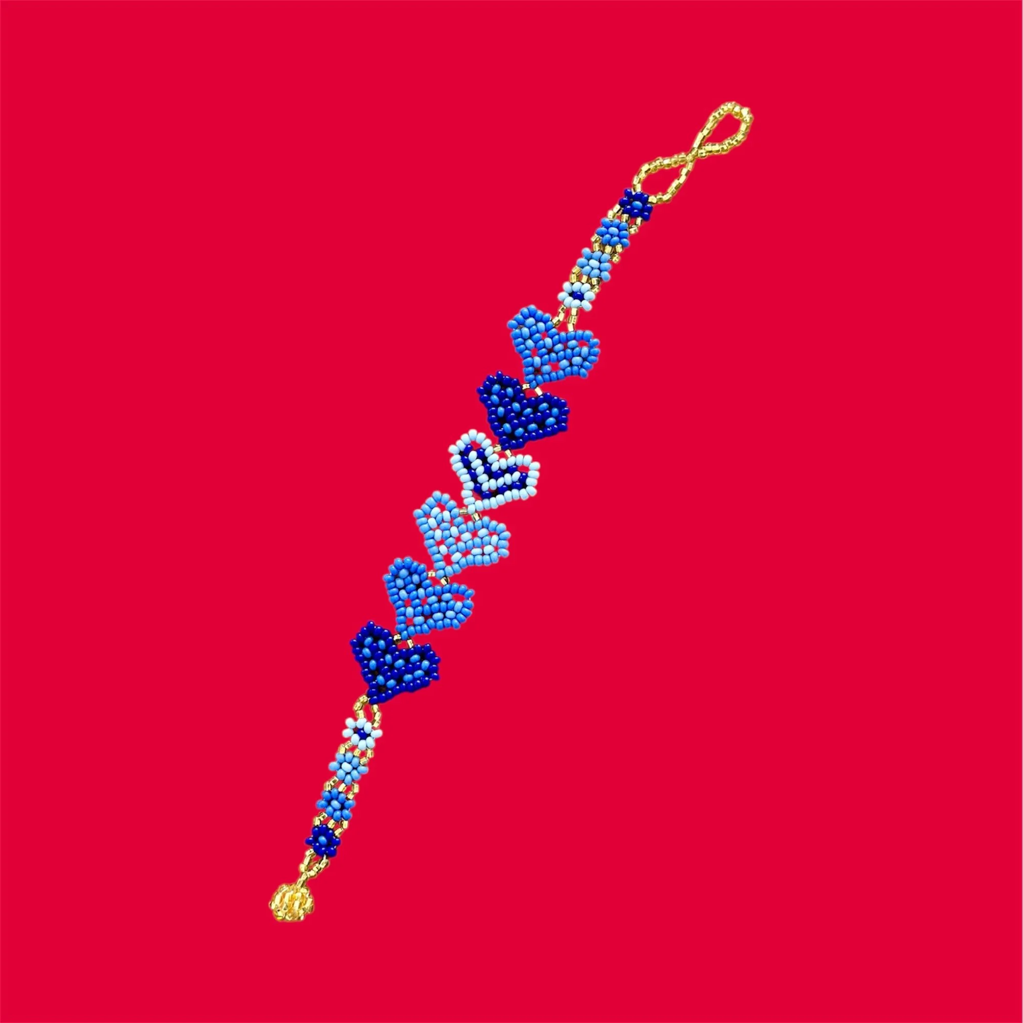 Otomi chaquira beaded bracelet with alternating blue heart motifs in cobalt blue and sky blue with gold-tone clasp