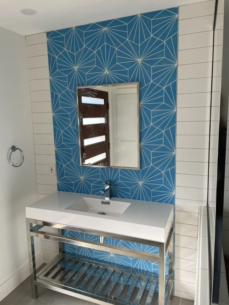 Bold tile and a polished console vanity refresh this compact powder room.