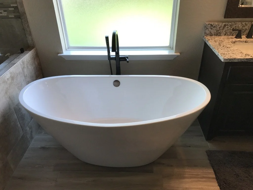 Centerpiece tub offers a quiet retreat with natural light and simple fixtures.