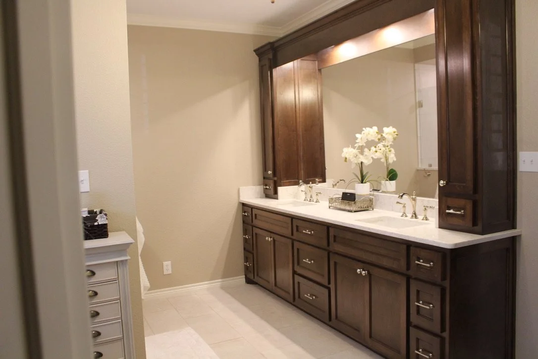 Classic bath update with warm wood cabinetry, bright task lighting, and a durable quartz surface.