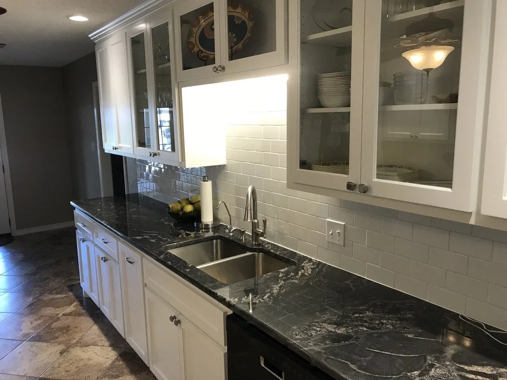 Clean galley run features glass uppers, under cabinet lighting, and easy care surfaces.