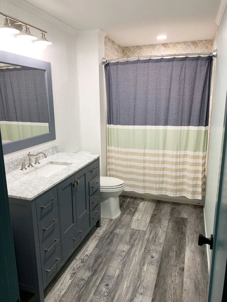 Compact bath refresh with quartz top, updated fixtures, and durable plank flooring.