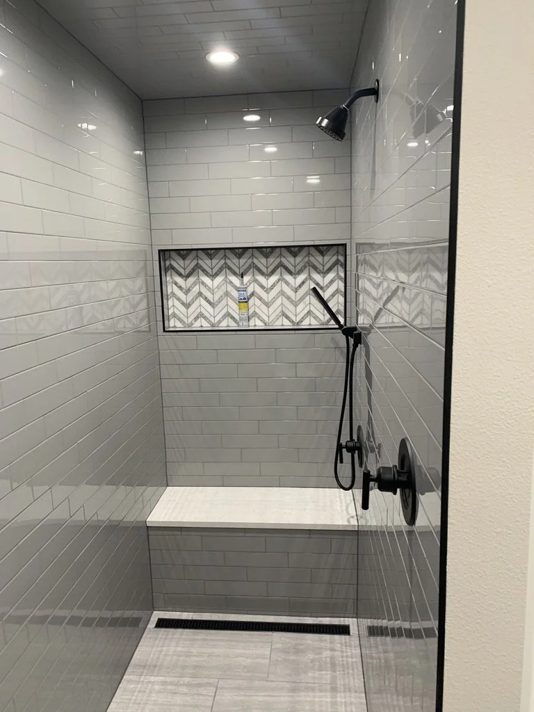 Walk in shower adds a built in bench and contrasting niche for everyday convenience.