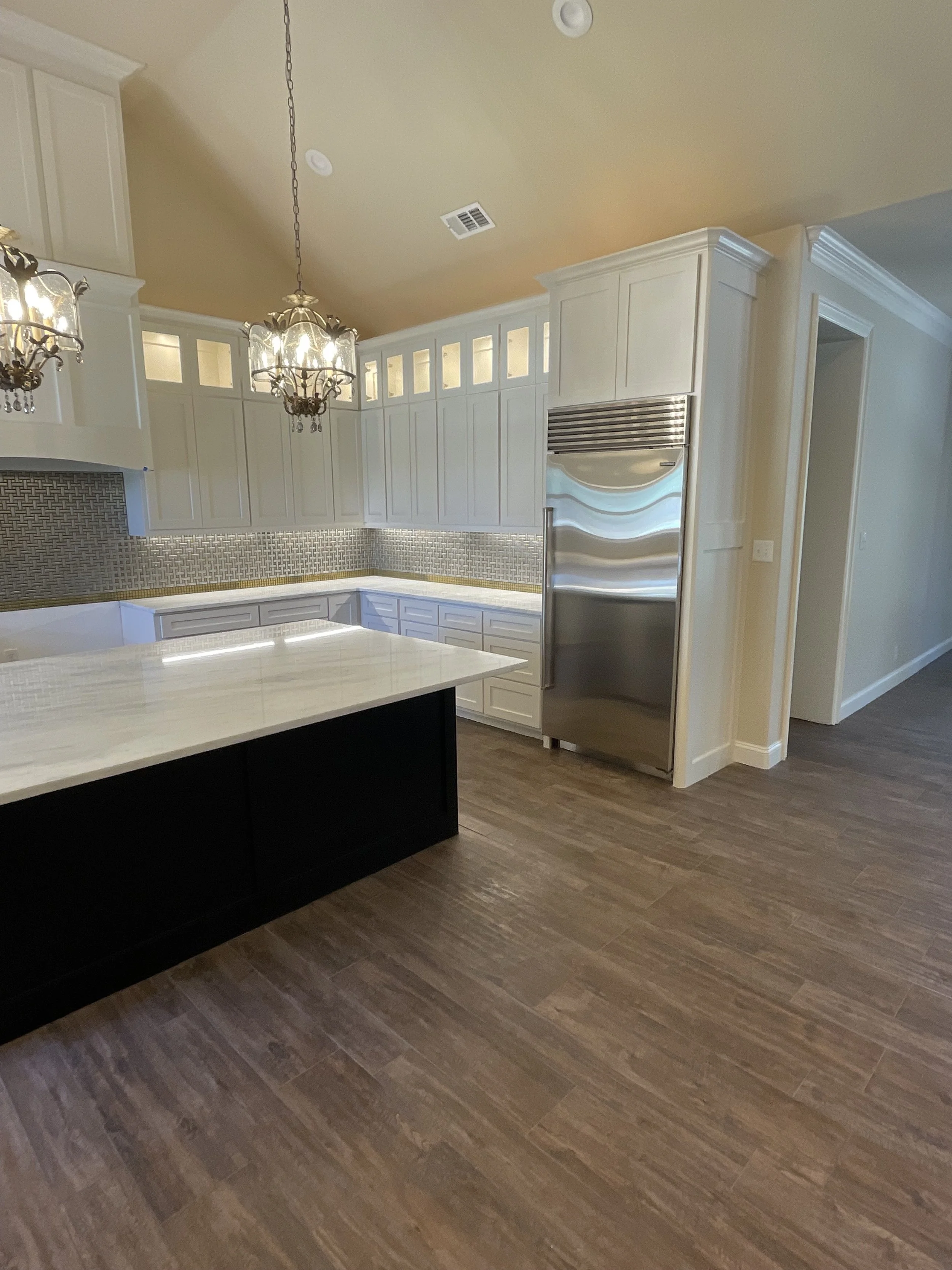 Expanded storage and statement lighting surround a central island.