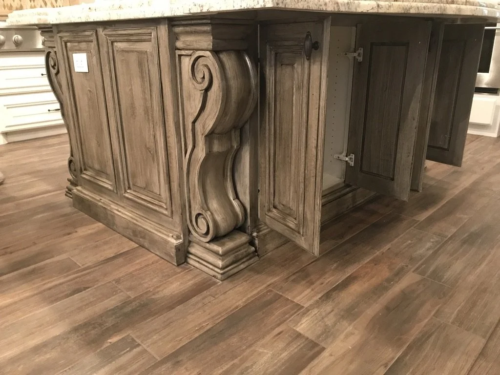 Hand-finished corbels and paneled millwork give the island a furniture-grade look.