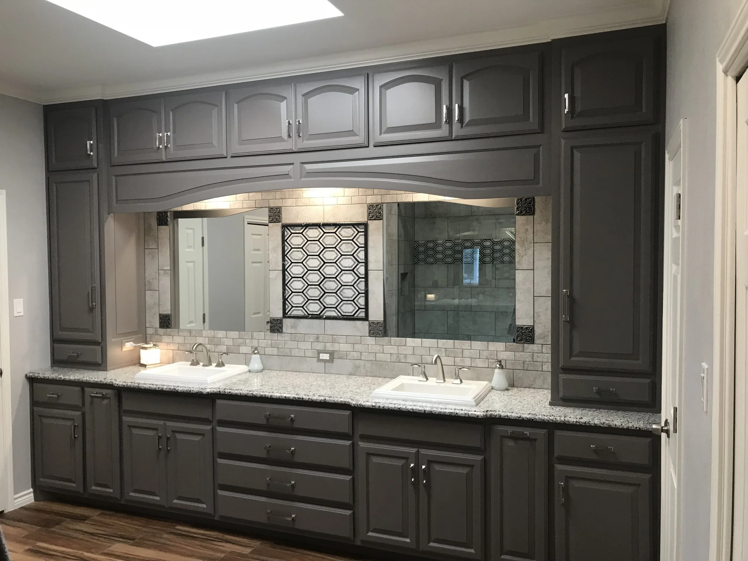 Expanded storage and twin sinks with framed mirrors and accent tile.