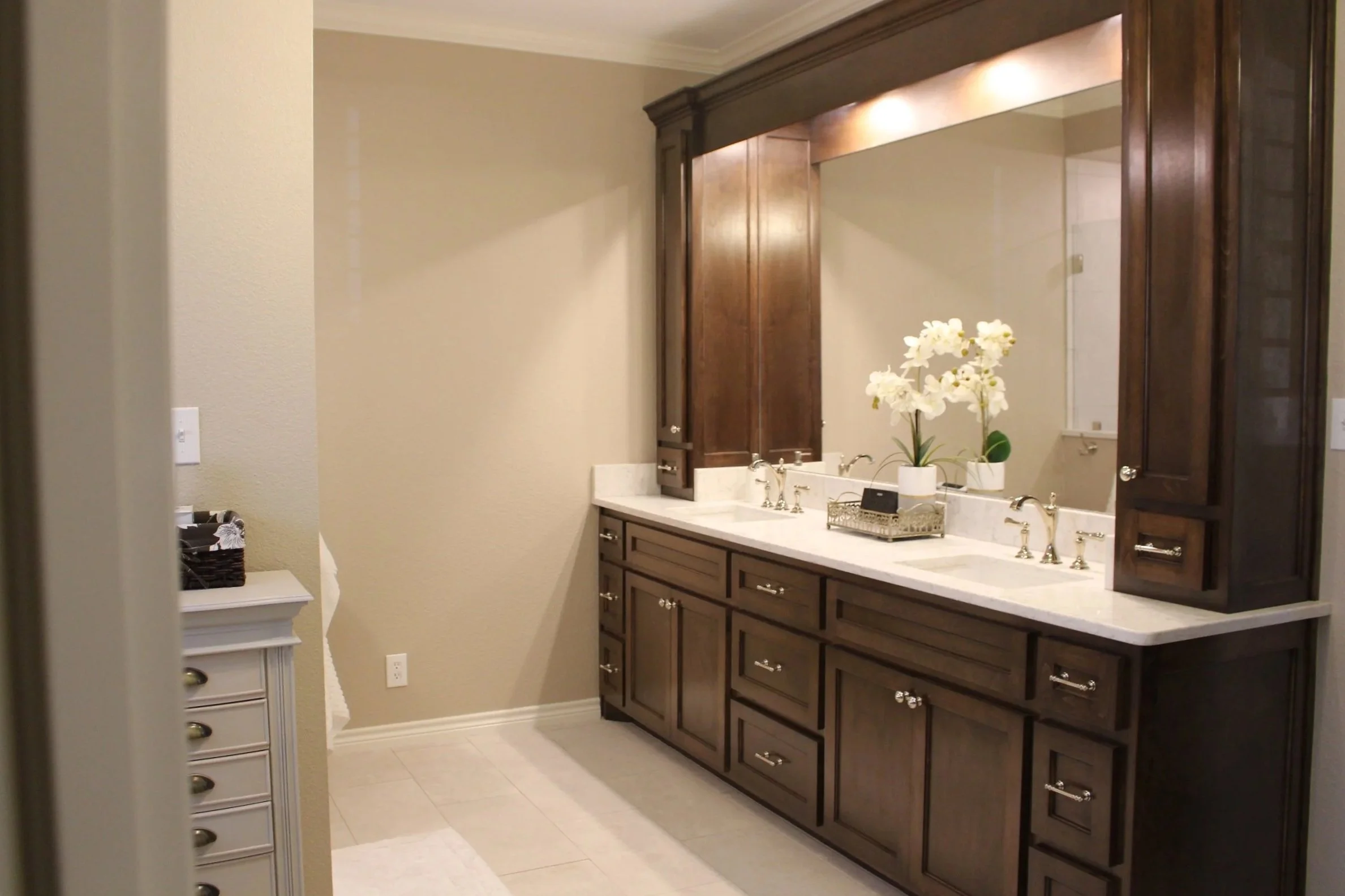 Rich wood cabinetry and bright task lighting refresh this bath suite.