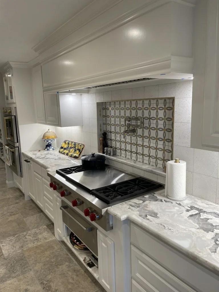Feature tile frames the cooking zone with task lighting and durable counters.