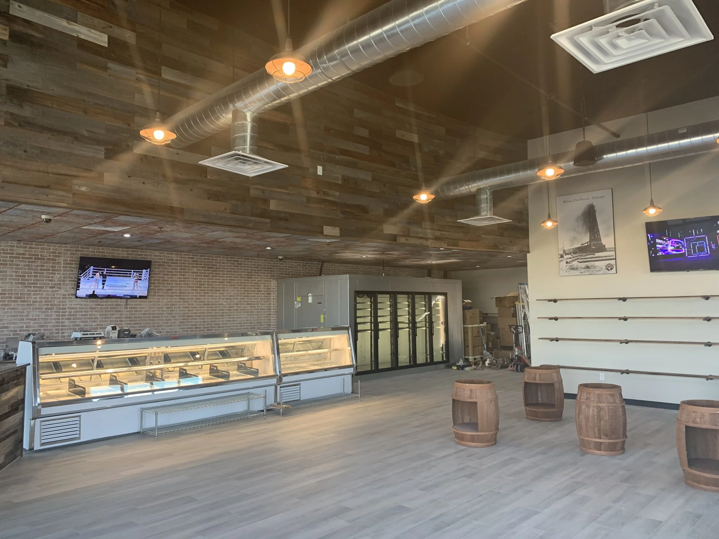 New retail layout with refrigerated cases, open ceiling, and durable flooring.