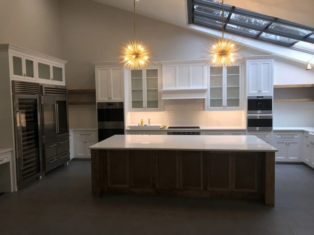 Lighting highlights the island workspace and skylight above the main prep zone.