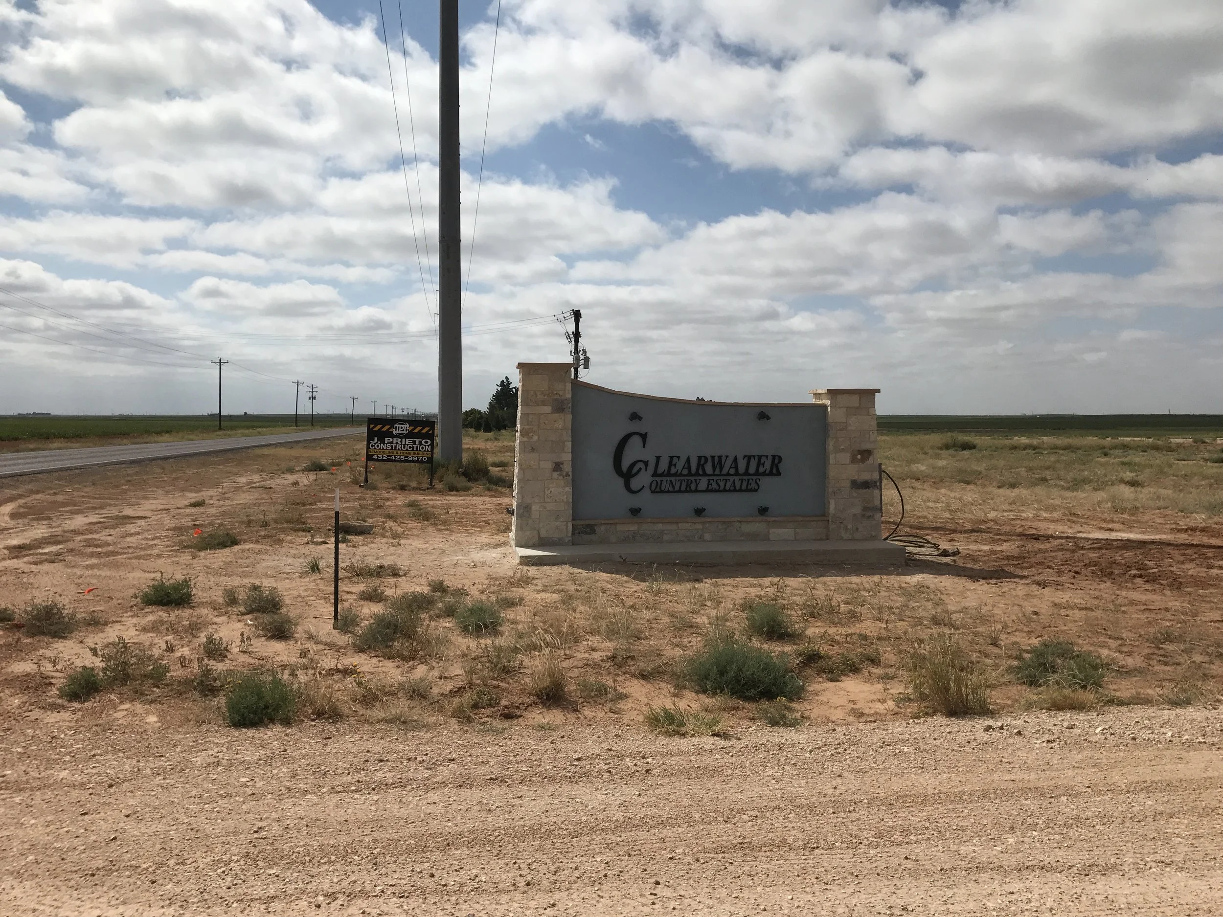 New entry marker with stone accents and routed lettering.