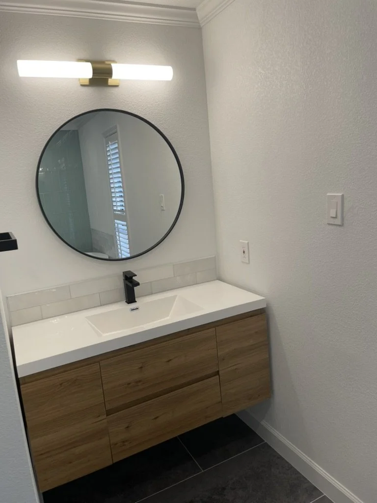 Warm wood tones and simple fixtures deliver a modern, low-maintenance bathroom.