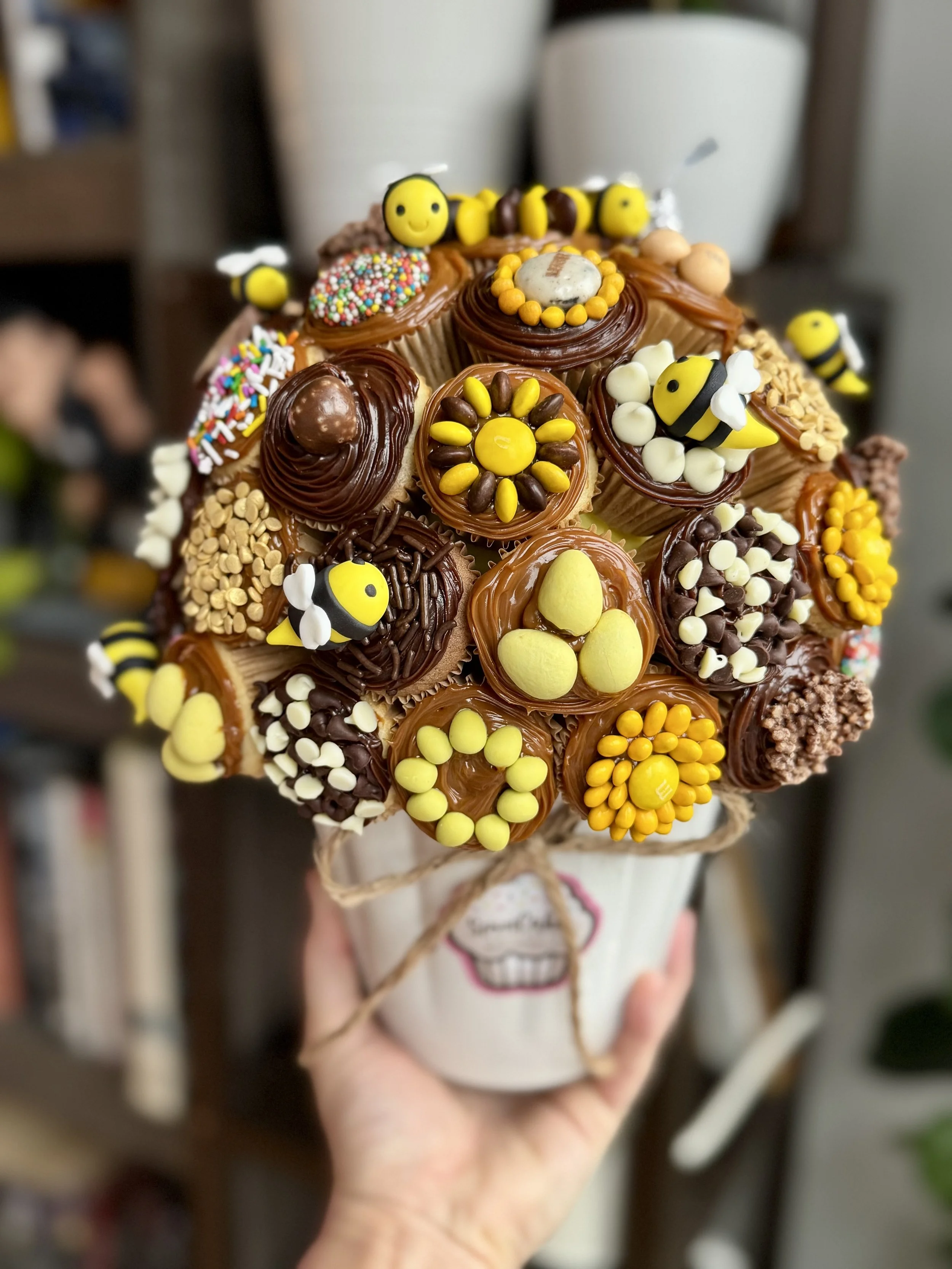 Mini cupcake bouquet with bee themed decorations in yellow and black tones