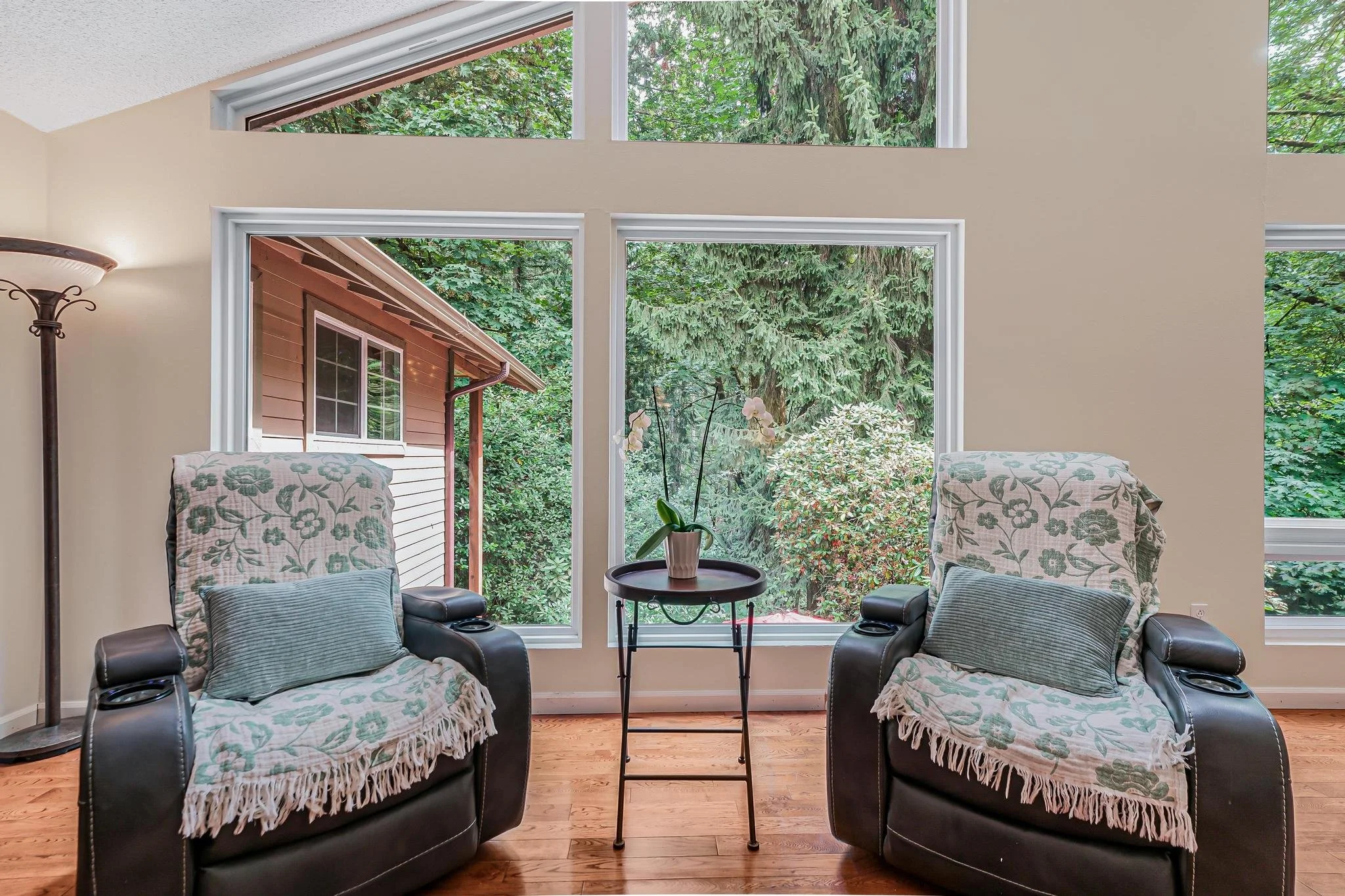 Comfortable chairs set by wide windows, offering residents a peaceful place to enjoy conversation or quiet moments while looking outdoors.