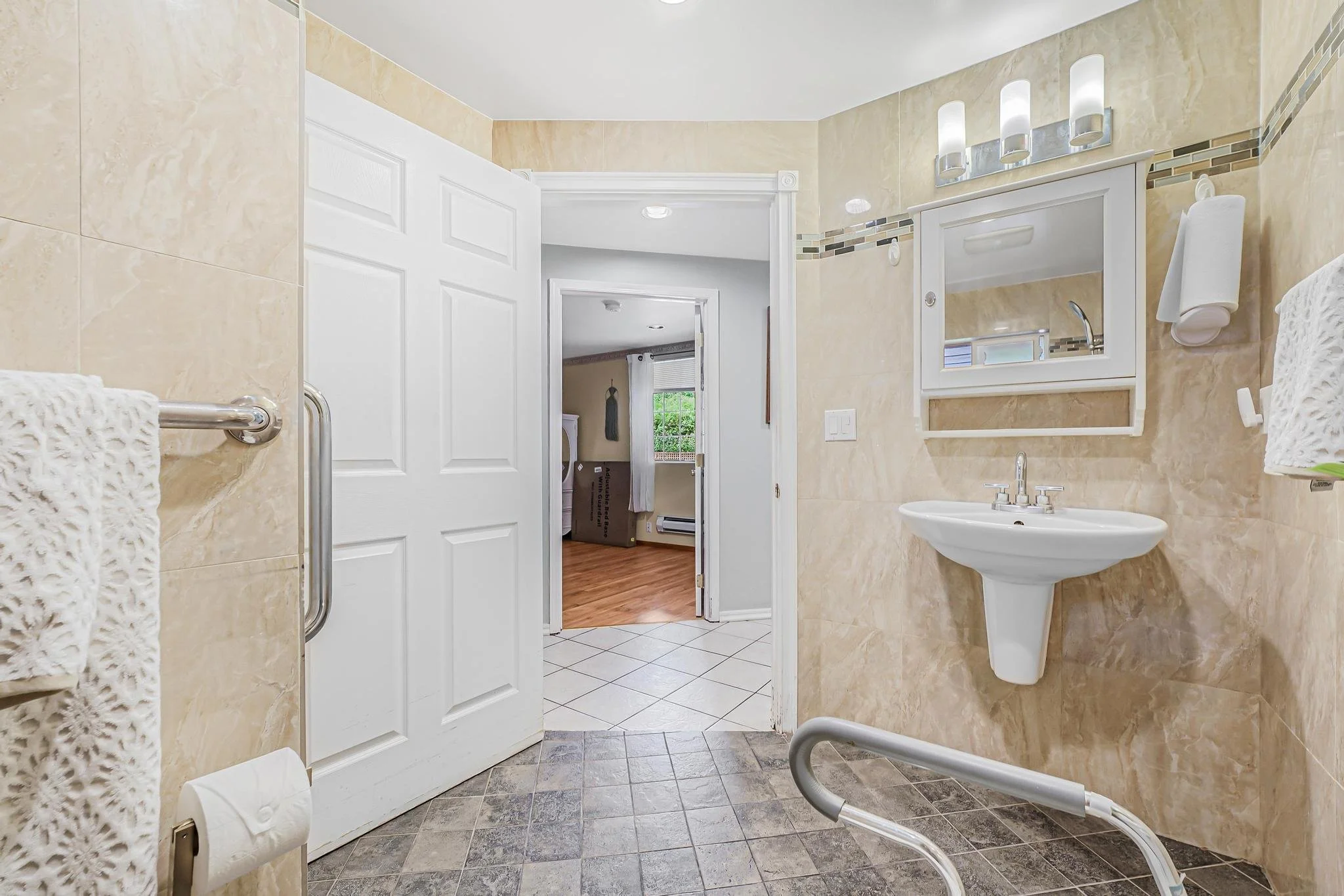 Bathroom with wide doorway and open layout that allows safe access for wheelchairs and walkers.