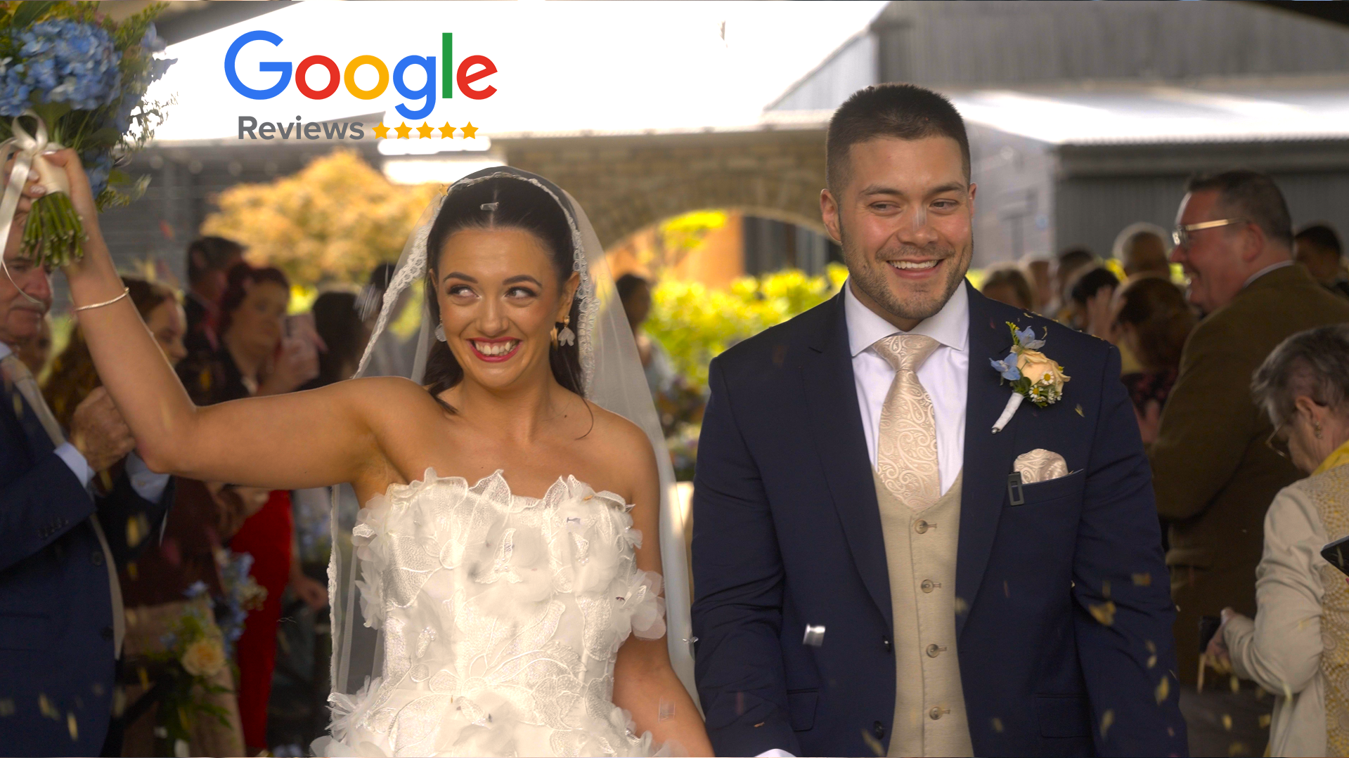 A bride and groom smiling during their wedding ceremony, surrounded by guests, with confetti falling around them.