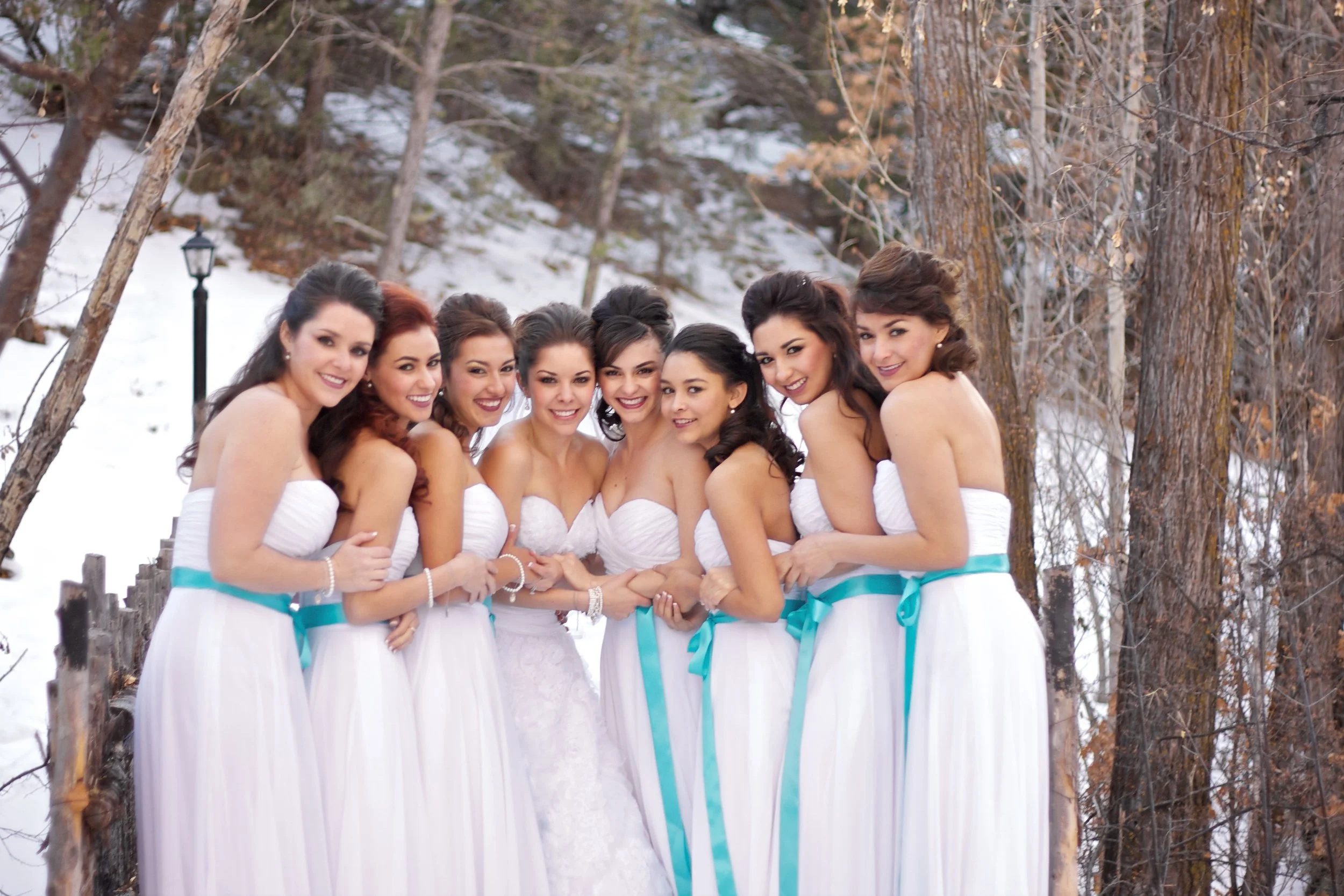 Group of women in white dresses outdoors in a snowy forest