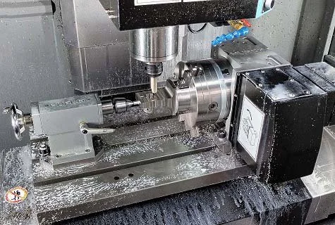 Close-up of a CNC machine tool, showing the spindle, cutting tool, and metal workpiece with metal shavings.