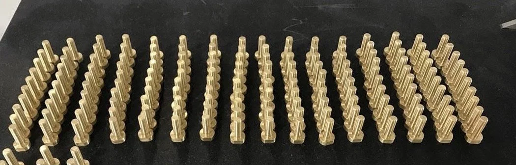 Multiple rows of gold-colored chess pawns on a black surface.