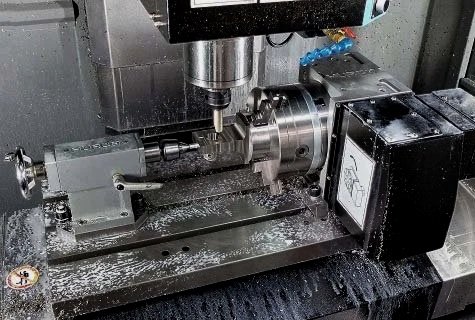 Close-up of a CNC milling machine with a metal workpiece being machined.