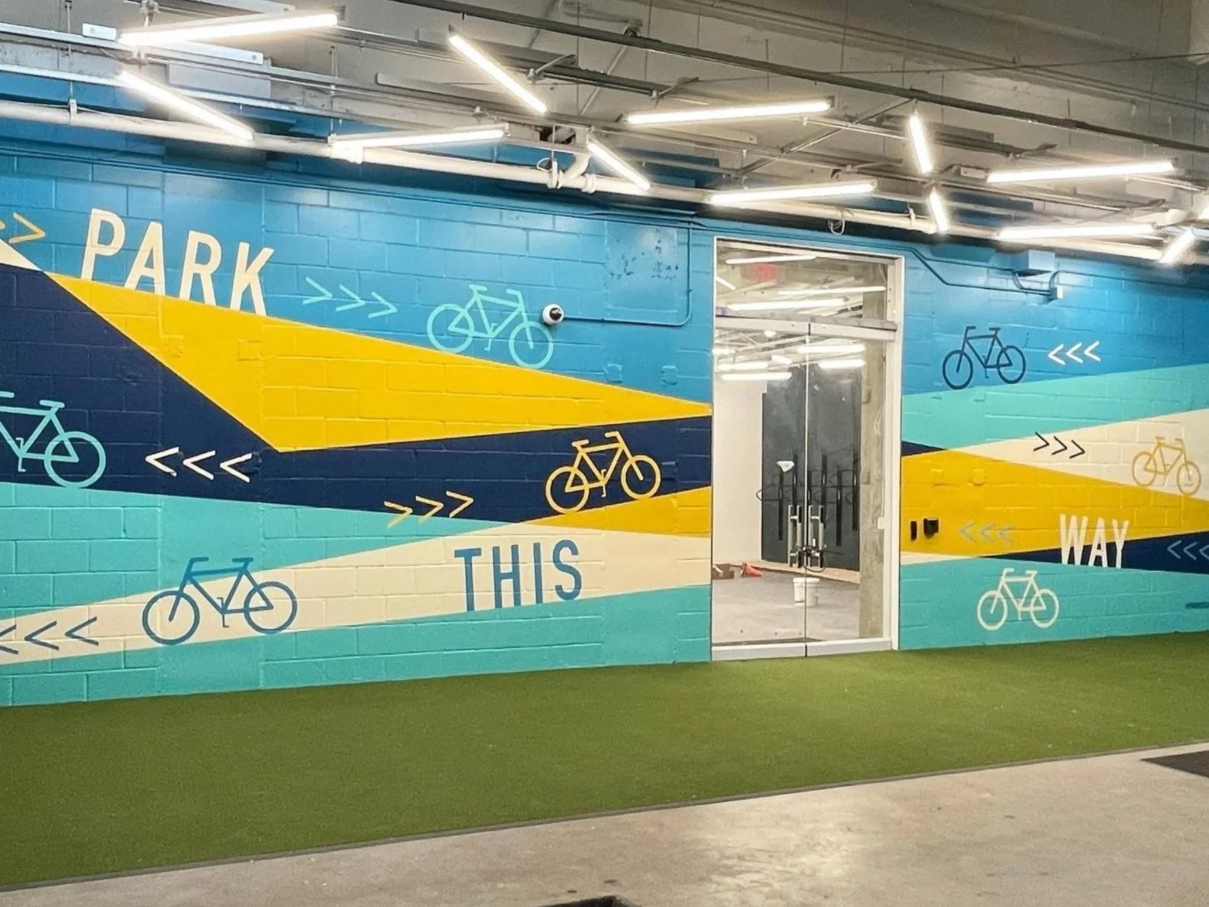 Bike parking area wayfinding handpainted by Pandr Design Co. in vibrant colors.