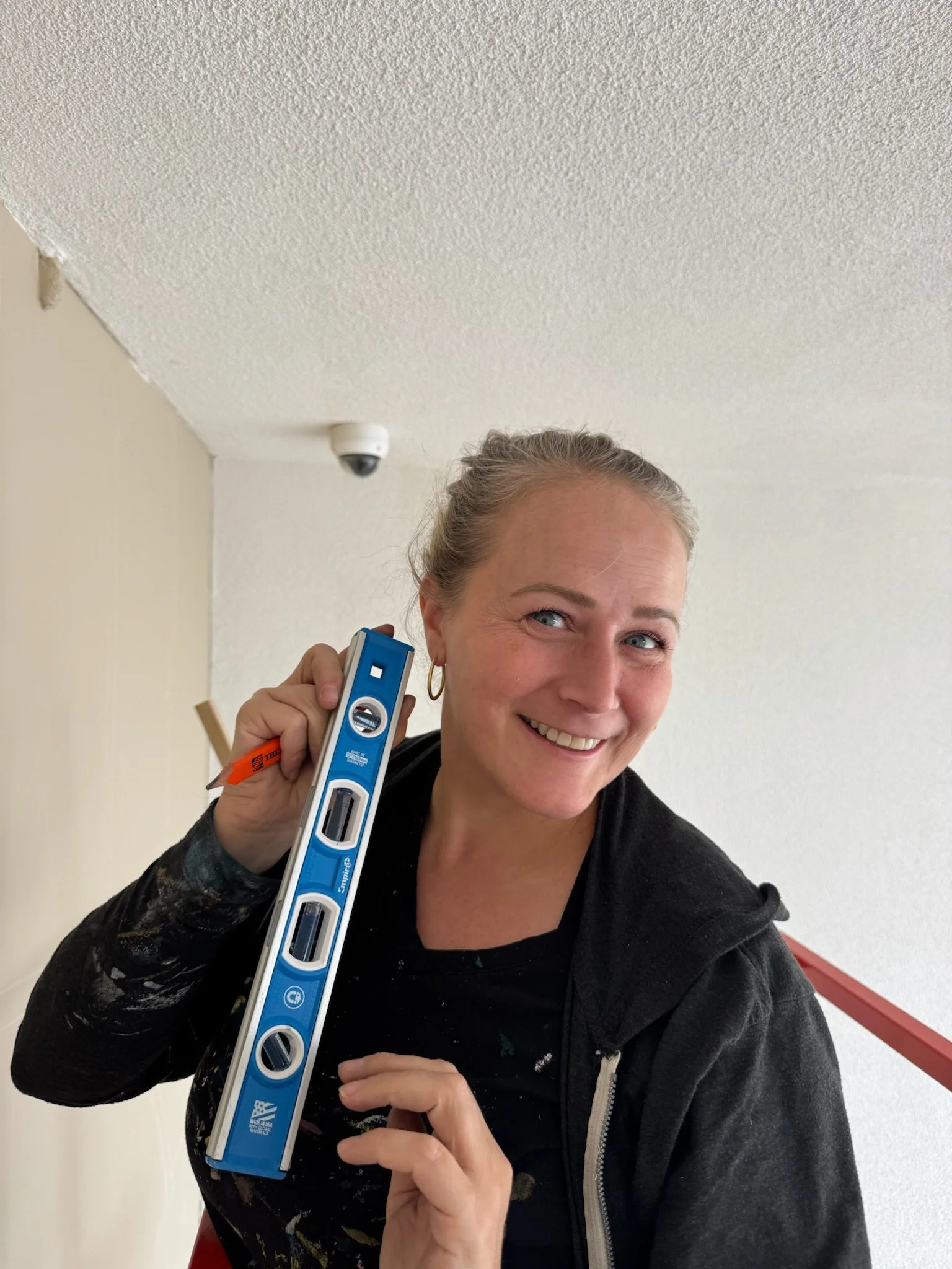 Pandr Design Co. team member holding up a level to showcase how to paint a mural.