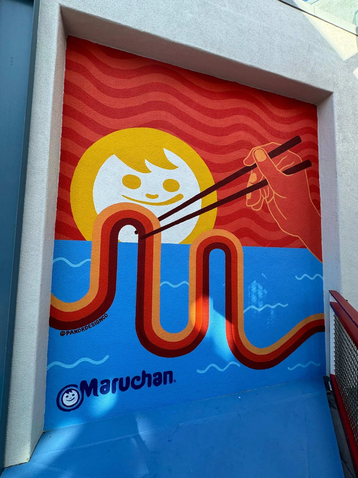 Primary colored mural painted by Pandr Design Co in San Diego showing noodles being pulled out of the ocean.