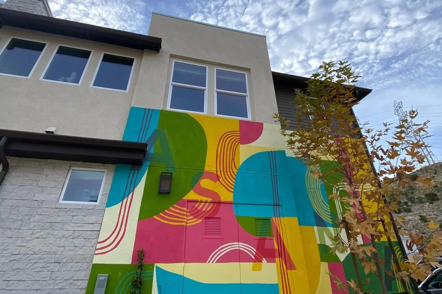 Colorful exterior of a model home showcasing pink,yellow,green,and blue by Pandr Design Co.