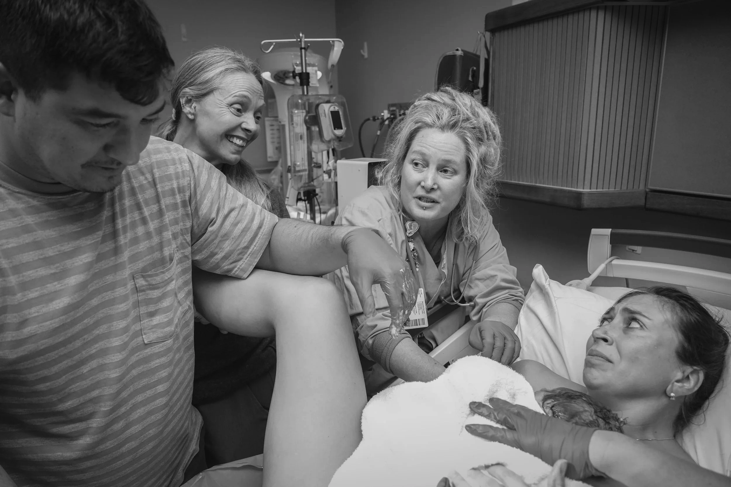 Midwife, partner, doula during childbirth in a hospital room at UF Flagler Health. Childbirth photography Alyssa Megeath. CNM Nicole Gress.