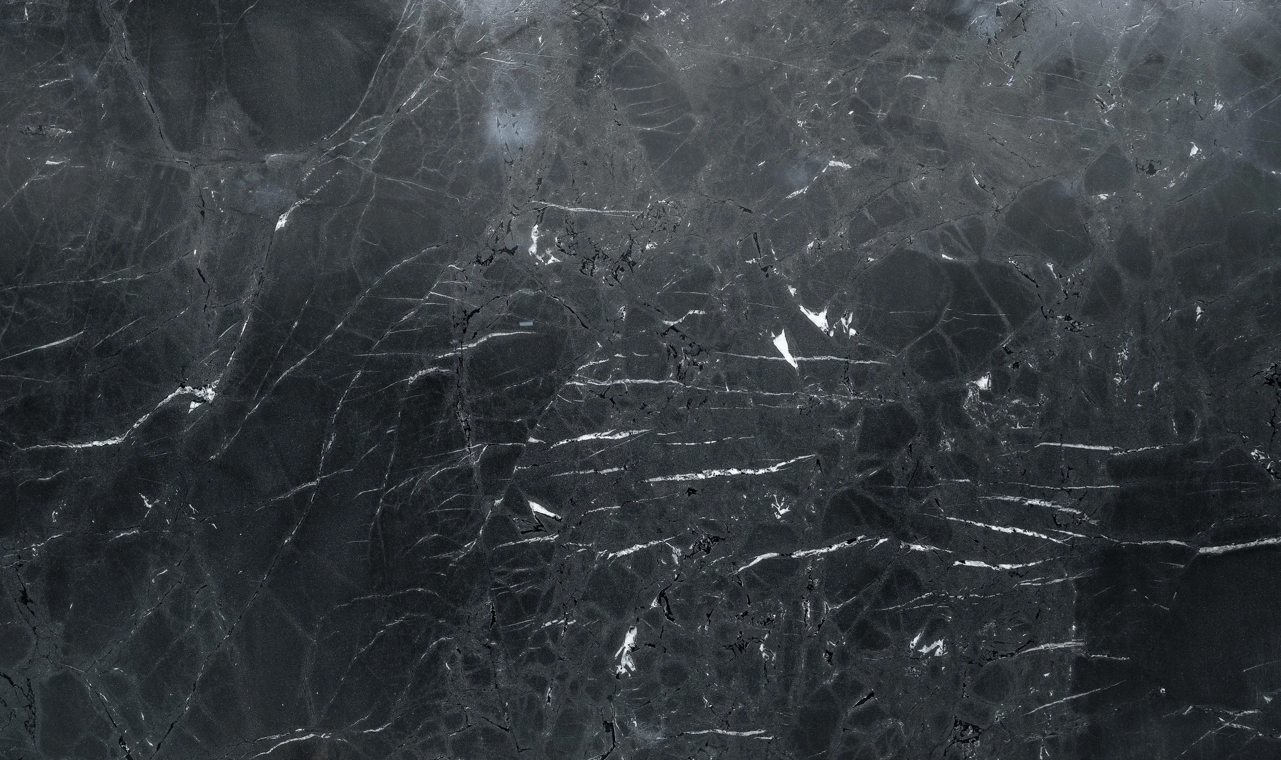 A close-up view of a dark grey and black marble surface with white veining.