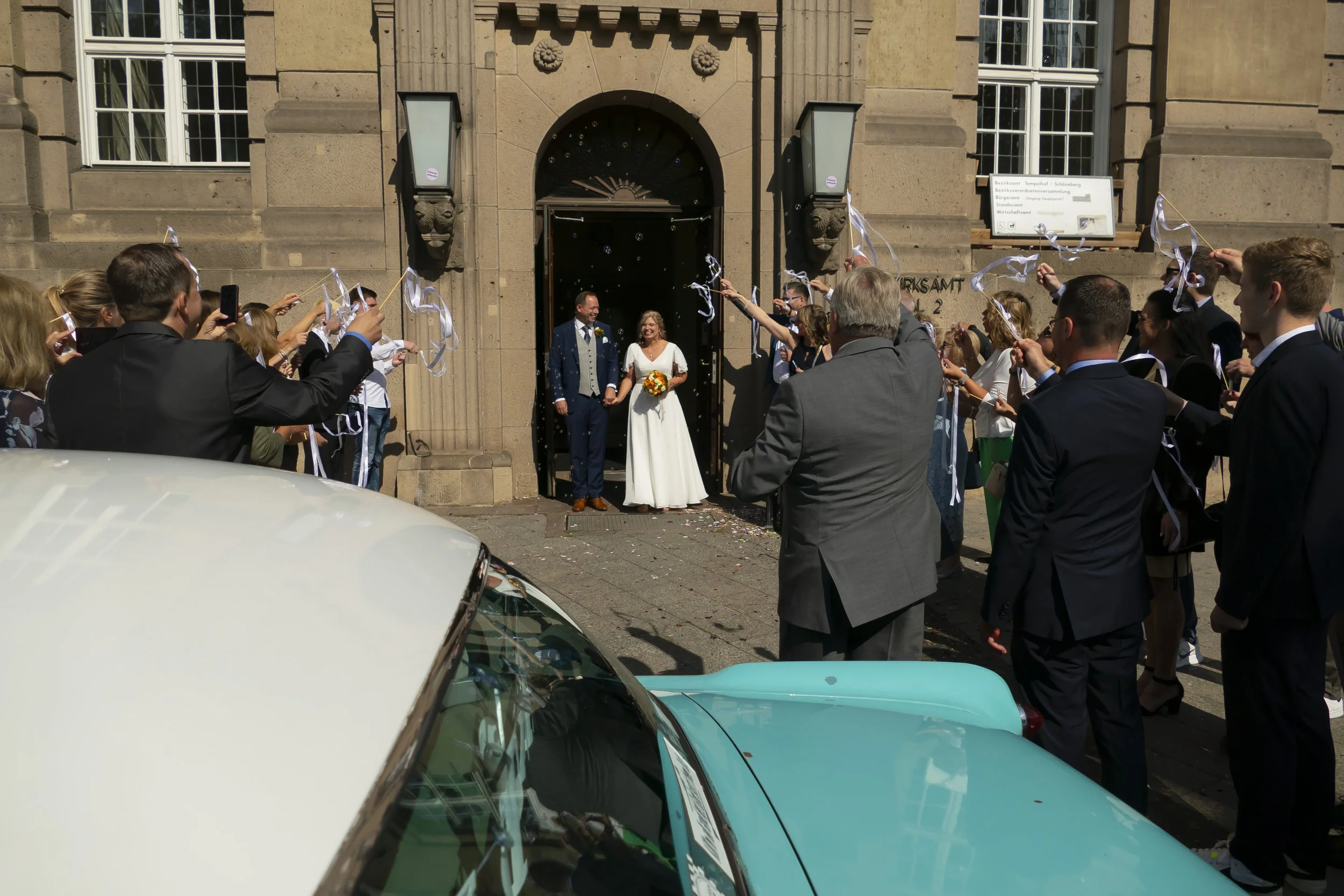 Ein Brautpaar verlässt das Standesamt Tempelhof-Schöneberg während einer Hochzeit