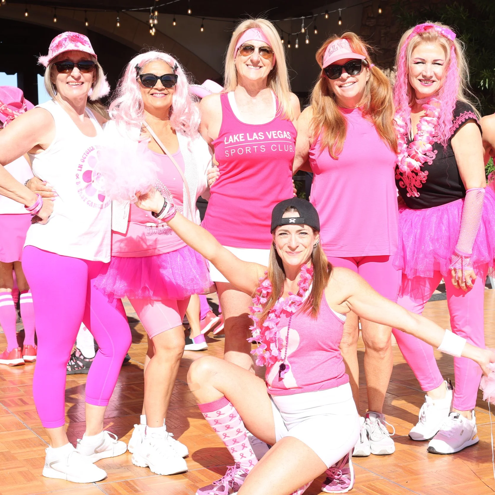 Lake Las Vegas Sport Club PInktober dressed in pink clothing and accessories, participating in a breast cancer awareness event, posing together outdoors.