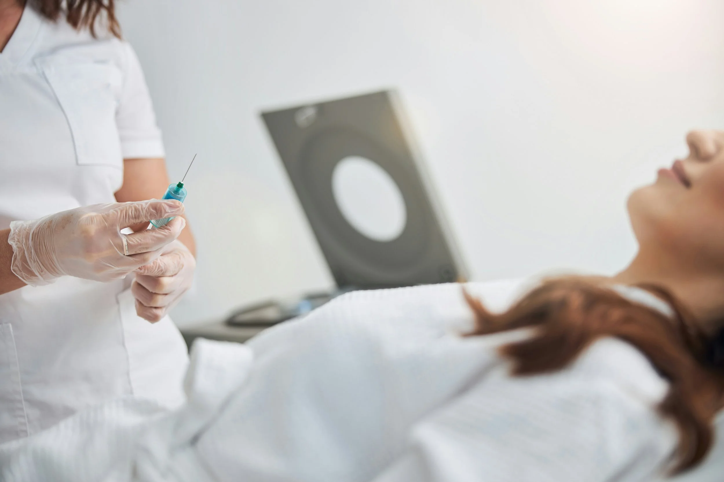 A woman on a treatment table waiting to get injected.