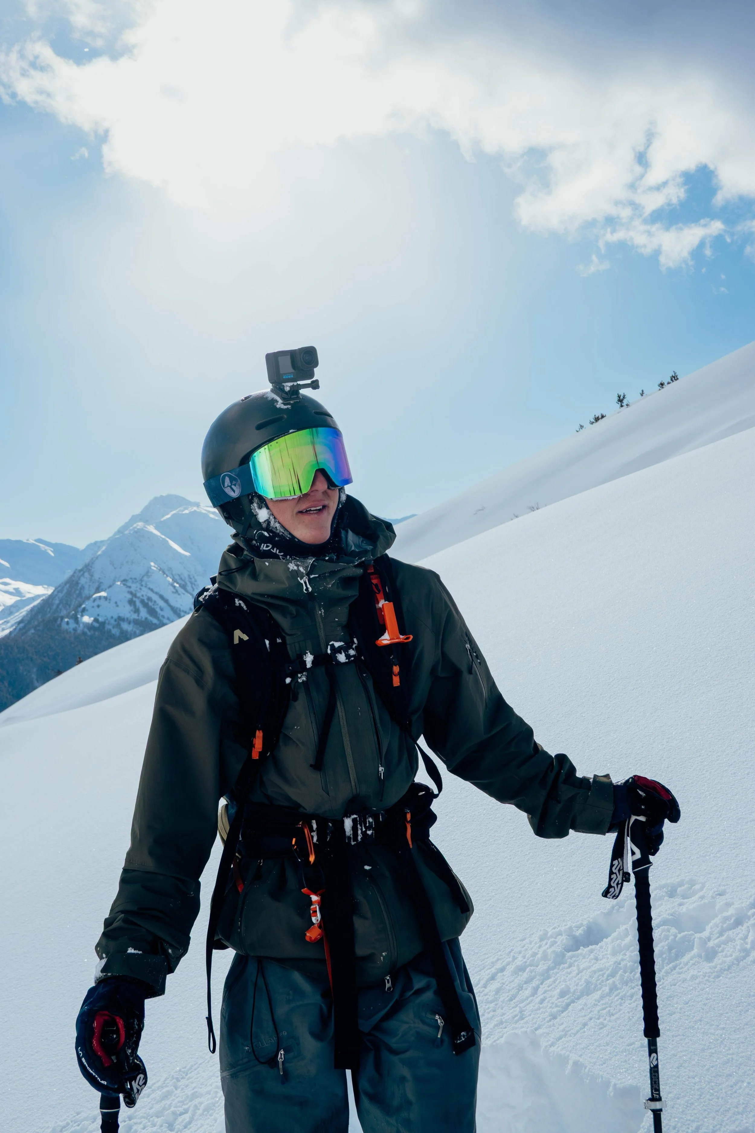 Ein Skifahrer fährt durch schneebedehnten Hang bei Schneesturm